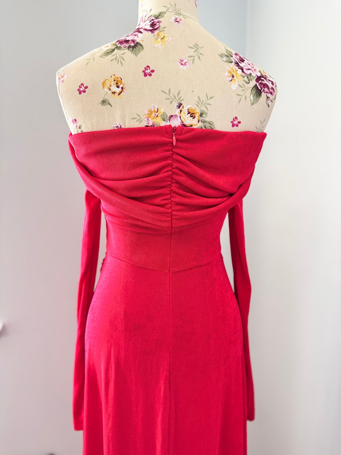 Introducing an exquisite statement piece: this stunning red off-the-shoulder gown is designed to turn heads with its timeless elegance and undeniable allure. Crafted from a soft, draping fabric that hugs your curves in all the right places, this dress features delicate ruched detailing at the waist, creating a flattering silhouette that enhances your natural beauty. The long, flowing sleeves add a touch of drama, while the fold-over neckline brings an effortlessly chic vibe.