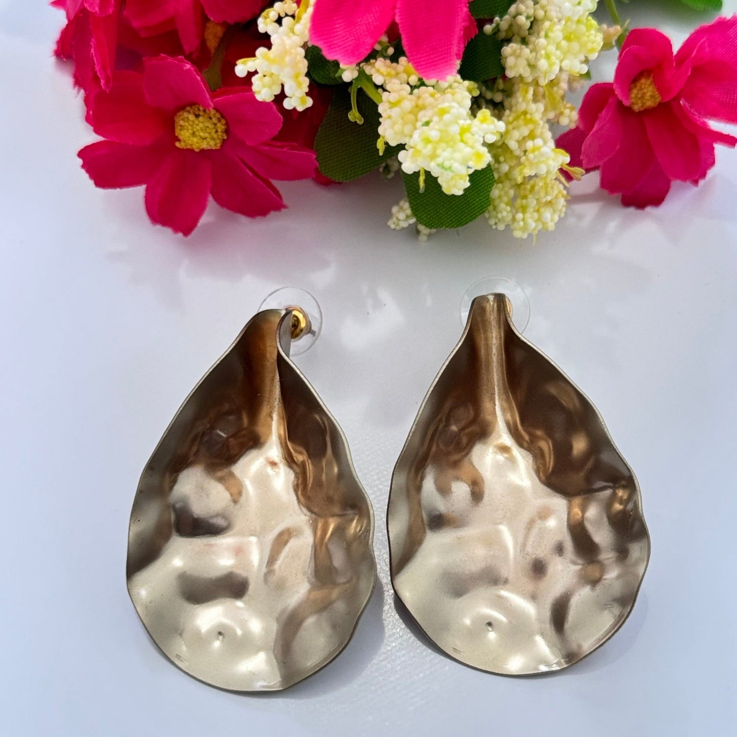 Introducing our Bold Gold Hammered Statement Earrings – a must-have for fashion-forward individuals who love to turn heads! These stunning teardrop-shaped earrings feature an organic, hand-hammered texture that shimmers beautifully with every movement, making them the perfect blend of elegance and boldness. C