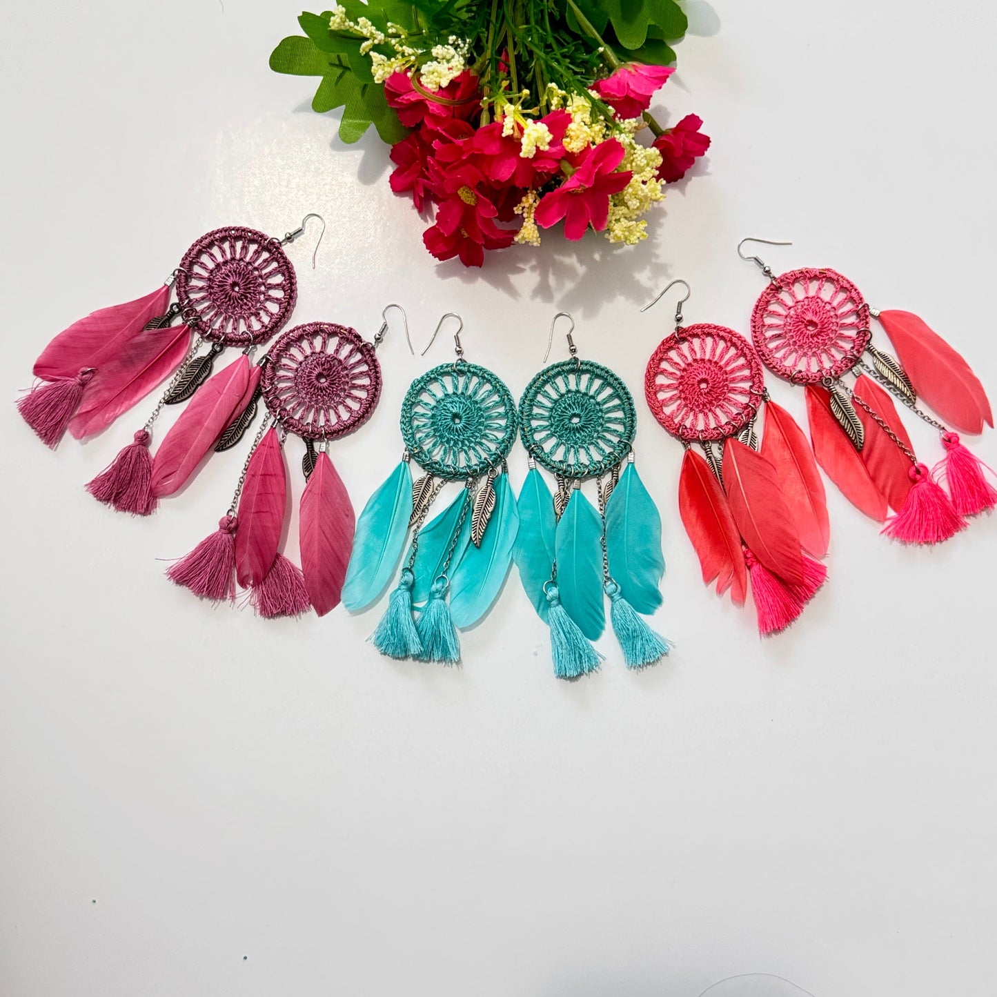 These intricately woven dreamcatcher-inspired earrings feature a stunning circular lace design, adorned with delicate feathers, silky tassels, and metallic leaf charms that sway beautifully with every movement.