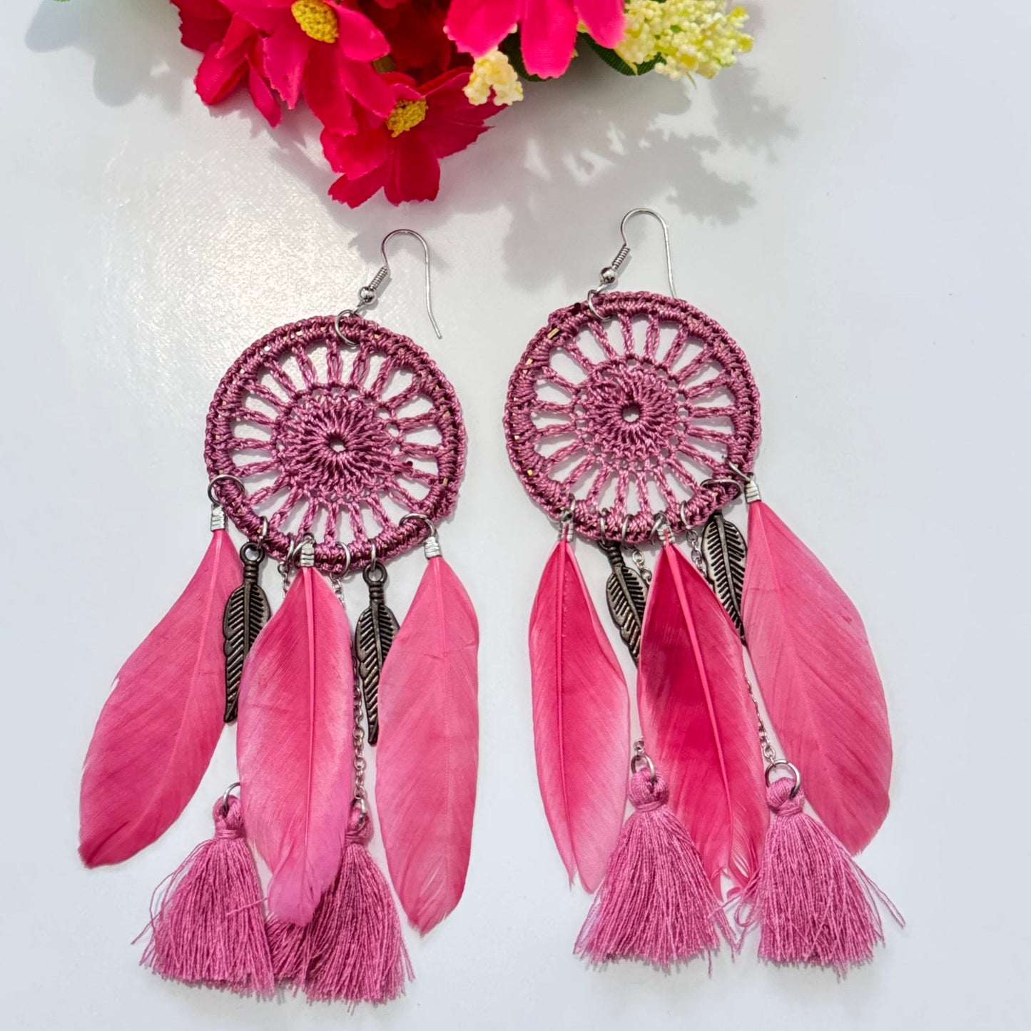 These intricately woven dreamcatcher-inspired earrings feature a stunning circular lace design, adorned with delicate feathers, silky tassels, and metallic leaf charms that sway beautifully with every movement.