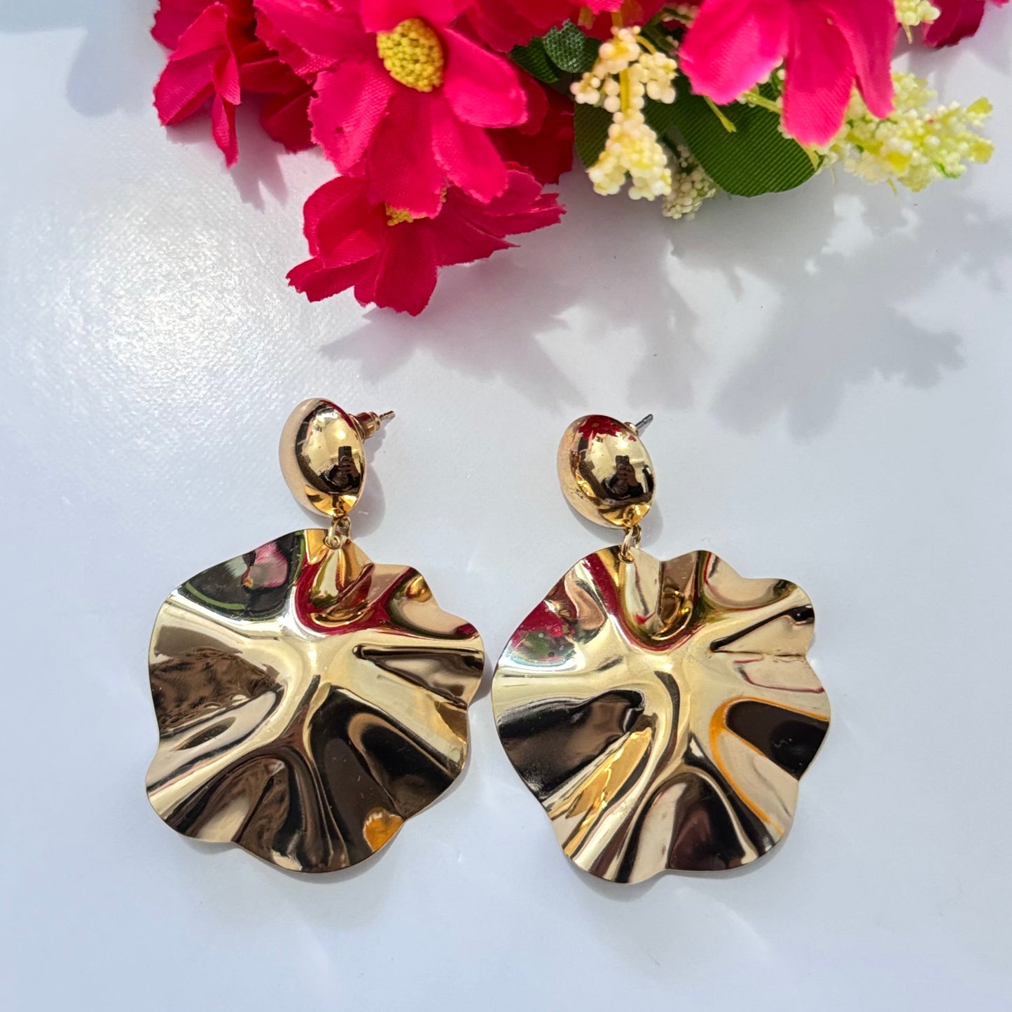 Unleash your inner elegance with these breathtaking gold statement earrings, designed to capture light and attention with every movement. Featuring a unique sculptural design inspired by the natural flow of molten gold, these earrings exude luxury, sophistication, and modern artistry. The fluid, wavy texture reflects light beautifully, adding a bold yet refined touch to any outfit.