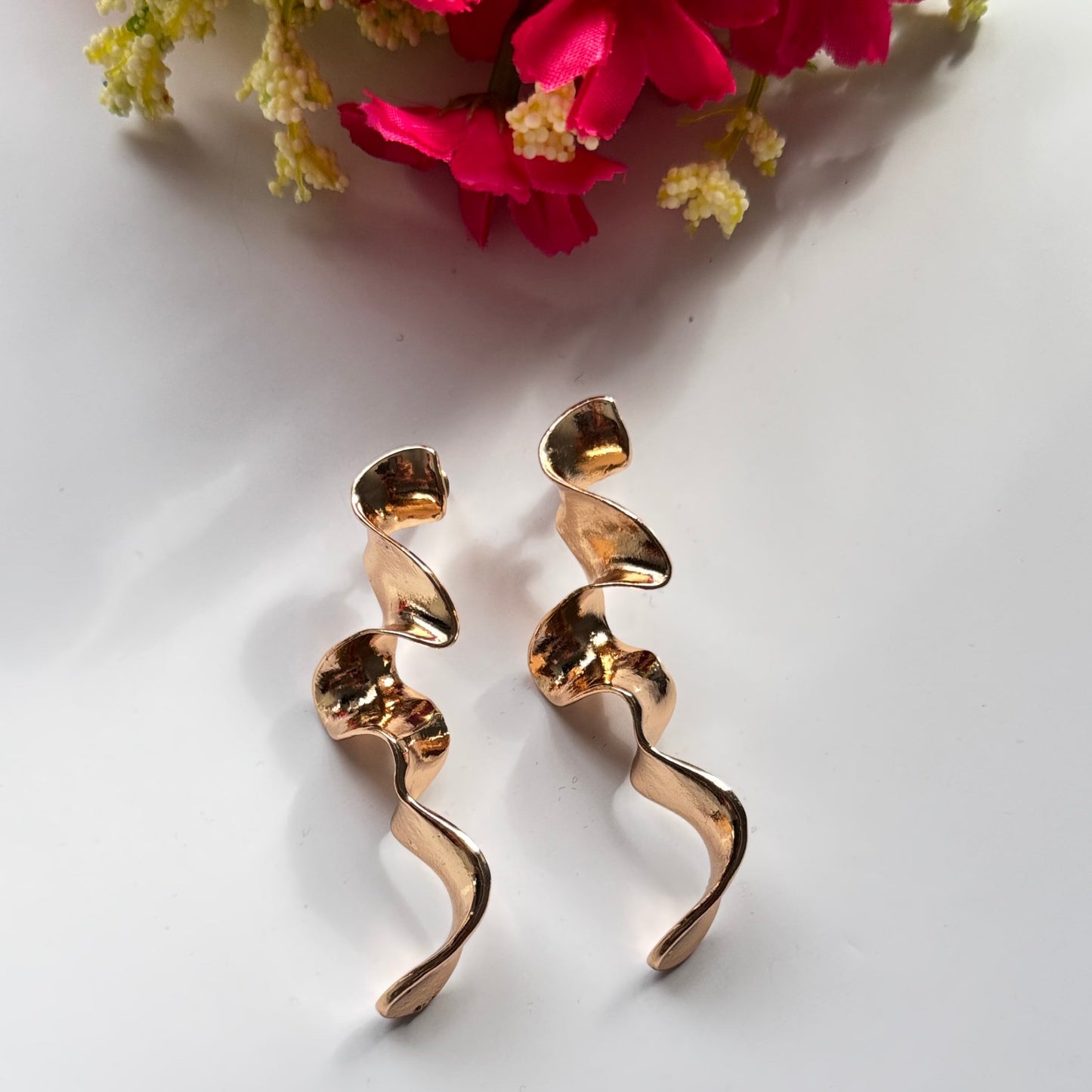 Elevate your style with these mesmerizing sculptural earrings, designed to turn heads and spark conversation. Featuring a stunning fluid wave design, these statement pieces are available in a radiant gold and sleek silver finish, each reflecting light beautifully to create a captivating shimmer with every movement.