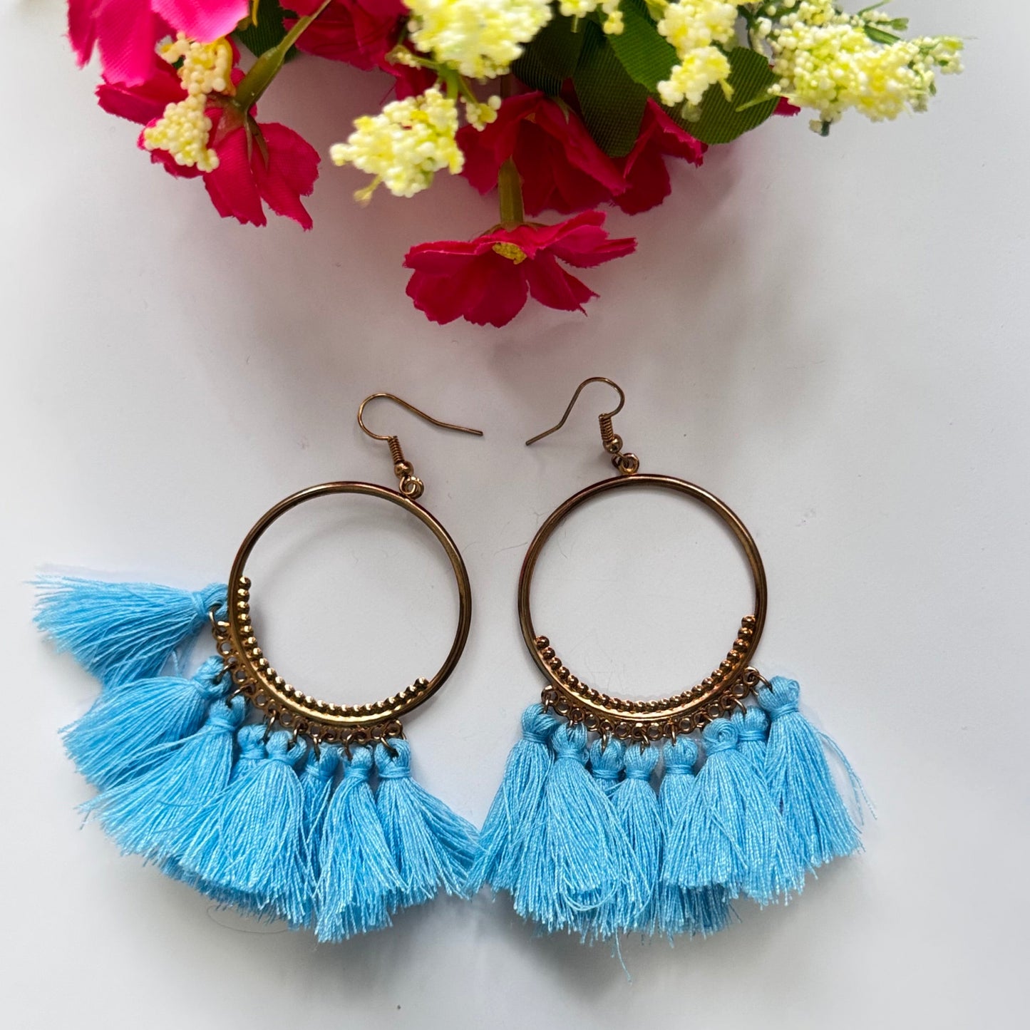 The perfect blend of elegance and bold style! Crafted with gold-tone hoops, these statement earrings feature vibrant, silky tassels in eye-catching shades of blue and magenta, designed to add a pop of color to any outfit.