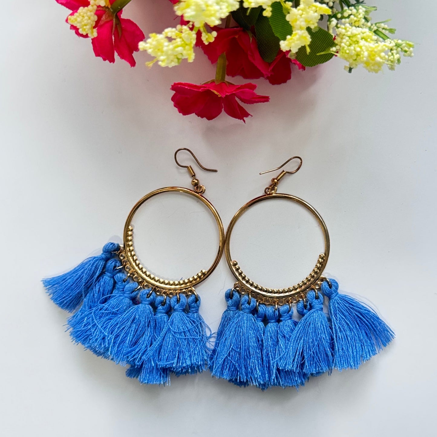The perfect blend of elegance and bold style! Crafted with gold-tone hoops, these statement earrings feature vibrant, silky tassels in eye-catching shades of blue and magenta, designed to add a pop of color to any outfit.