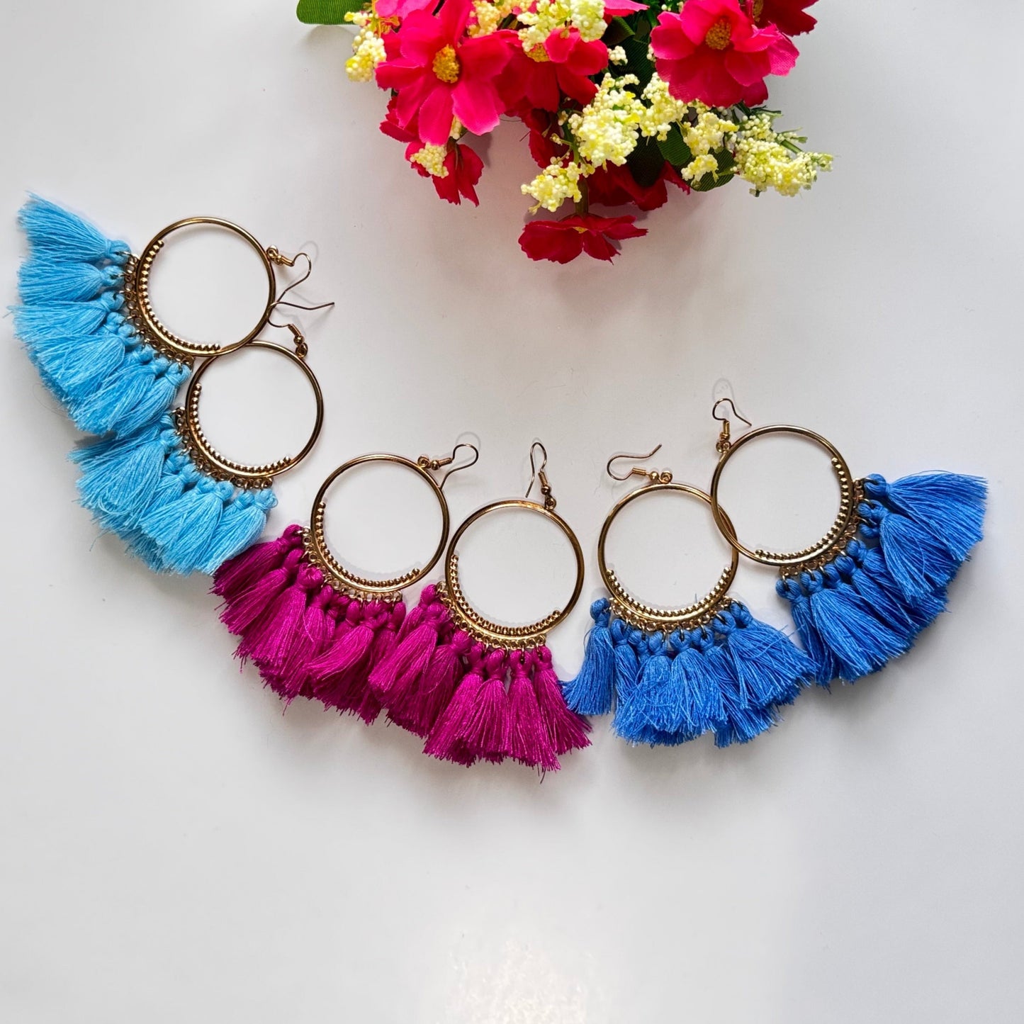 The perfect blend of elegance and bold style! Crafted with gold-tone hoops, these statement earrings feature vibrant, silky tassels in eye-catching shades of blue and magenta, designed to add a pop of color to any outfit