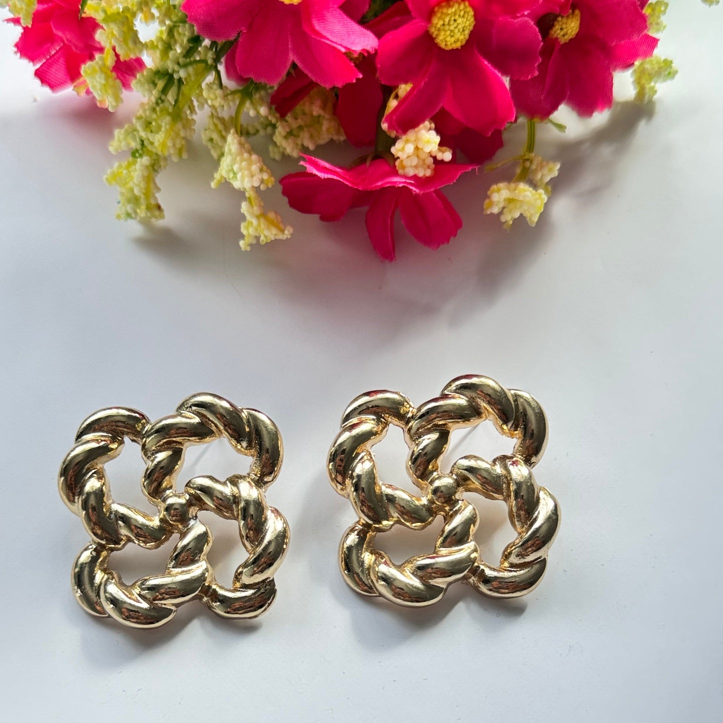 Make a bold and sophisticated statement with these exquisite gold-tone knot earrings, designed to add a touch of timeless elegance to any outfit. Featuring an intricate twisted rope design in a chic floral-inspired shape, these earrings radiate luxury and refinement.
