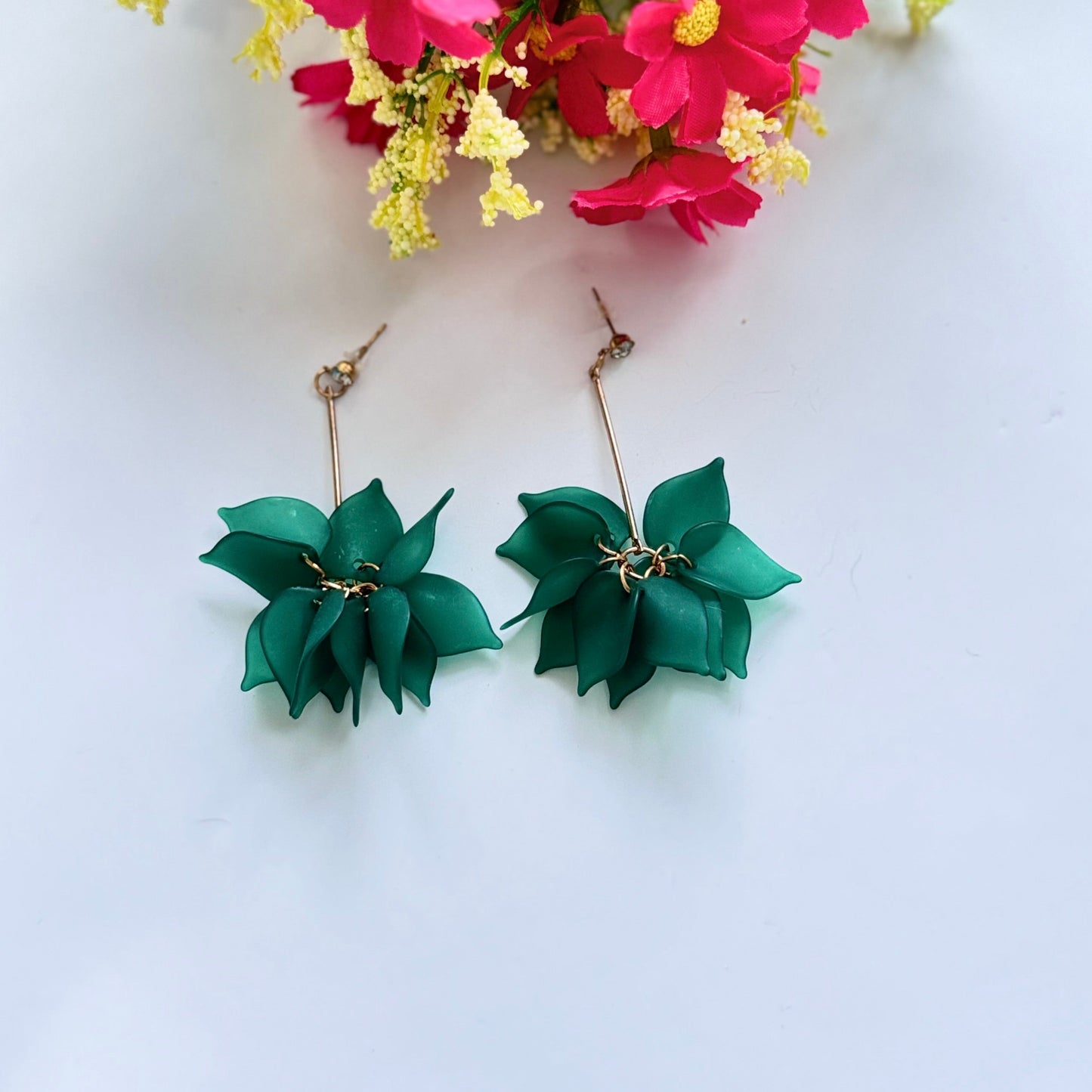 Embrace nature-inspired elegance with these stunning floral drop earrings, designed to add a fresh and feminine touch to any outfit. Featuring delicate, layered petals in rich emerald green, classic white, and vibrant orange, these statement pieces exude charm and sophistication. Suspended from sleek gold-tone accents, they offer a perfect balance of bold color and lightweight comfort.
