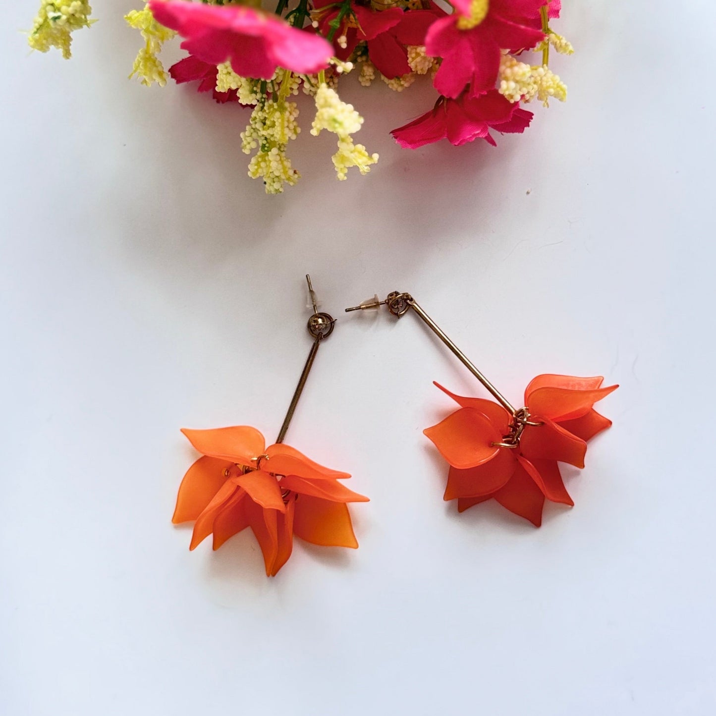 Embrace nature-inspired elegance with these stunning floral drop earrings, designed to add a fresh and feminine touch to any outfit. Featuring delicate, layered petals in rich emerald green, classic white, and vibrant orange, these statement pieces exude charm and sophistication. Suspended from sleek gold-tone accents, they offer a perfect balance of bold color and lightweight comfort.