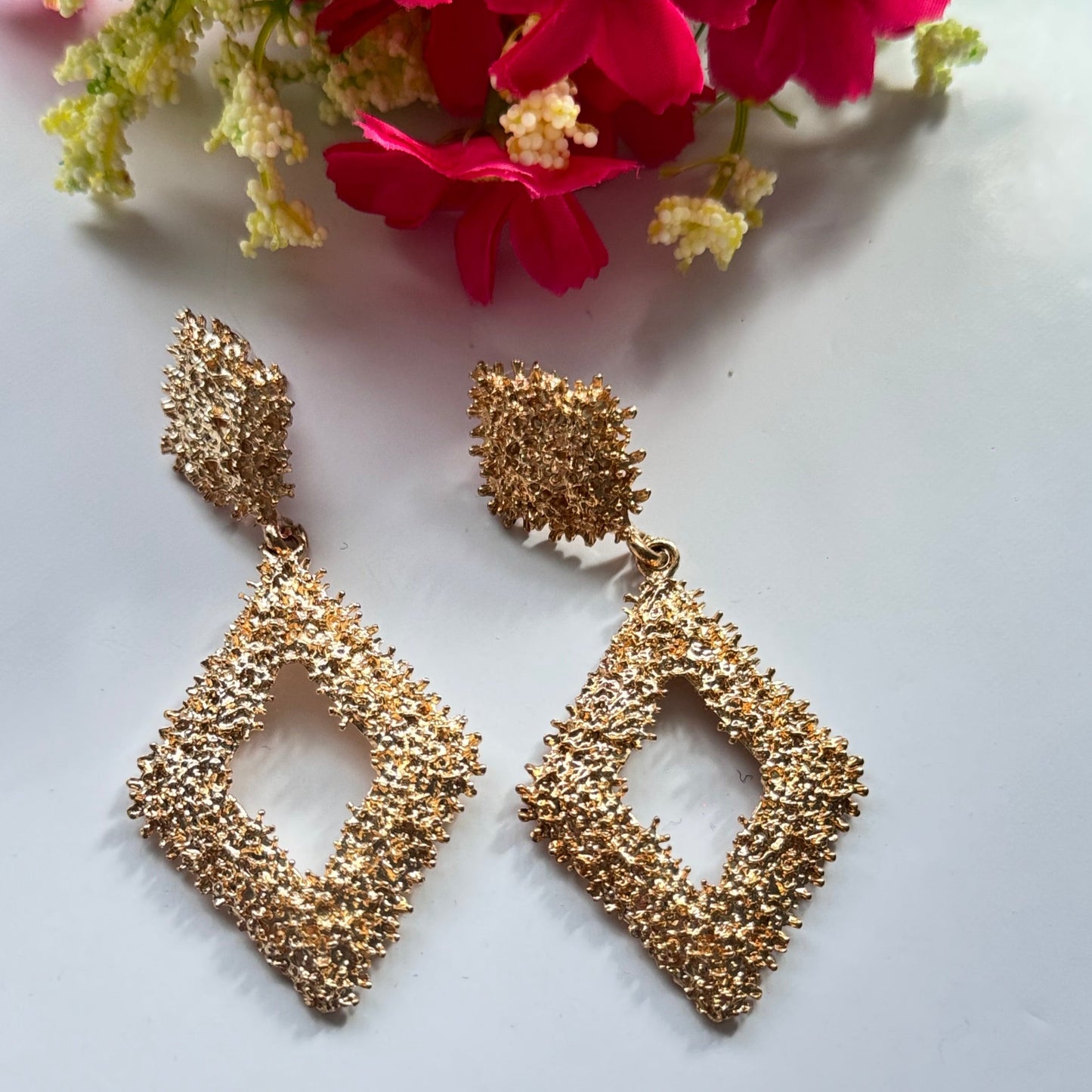 Elevate your style with these dazzling geometric statement earrings, designed to add a touch of elegance and modern sophistication to any outfit. Crafted with a unique textured finish, these bold earrings come in both radiant gold and shimmering silver.