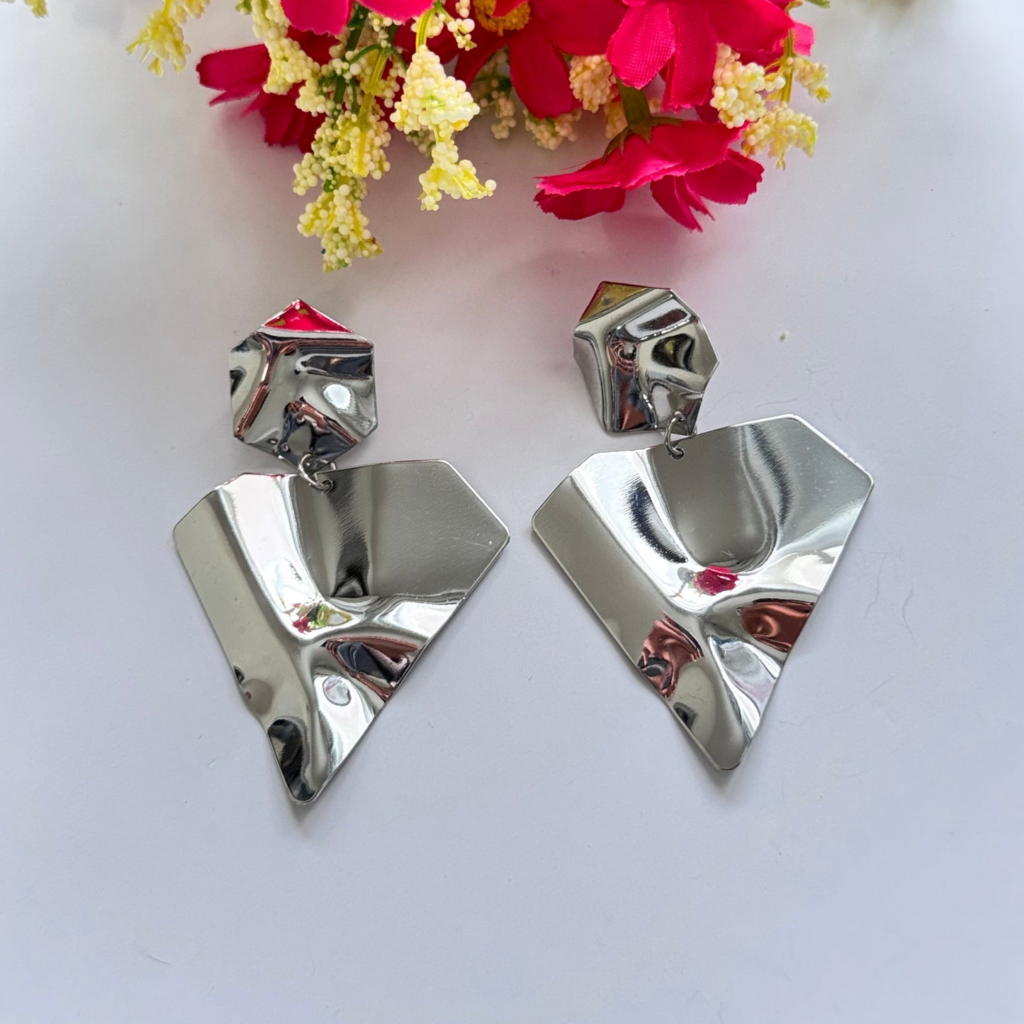 Make a bold statement with these ultra-modern, sculpted silver earrings, designed for those who love edgy sophistication. Featuring a high-shine, crumpled metal effect, these geometric statement pieces exude contemporary elegance with an artistic twist.
