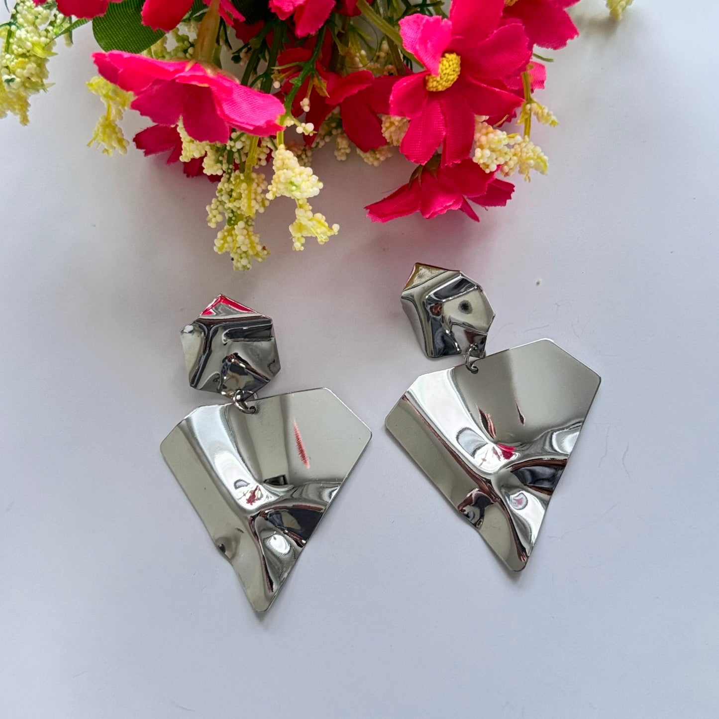 Make a bold statement with these ultra-modern, sculpted silver earrings, designed for those who love edgy sophistication. Featuring a high-shine, crumpled metal effect, these geometric statement pieces exude contemporary elegance with an artistic twist.