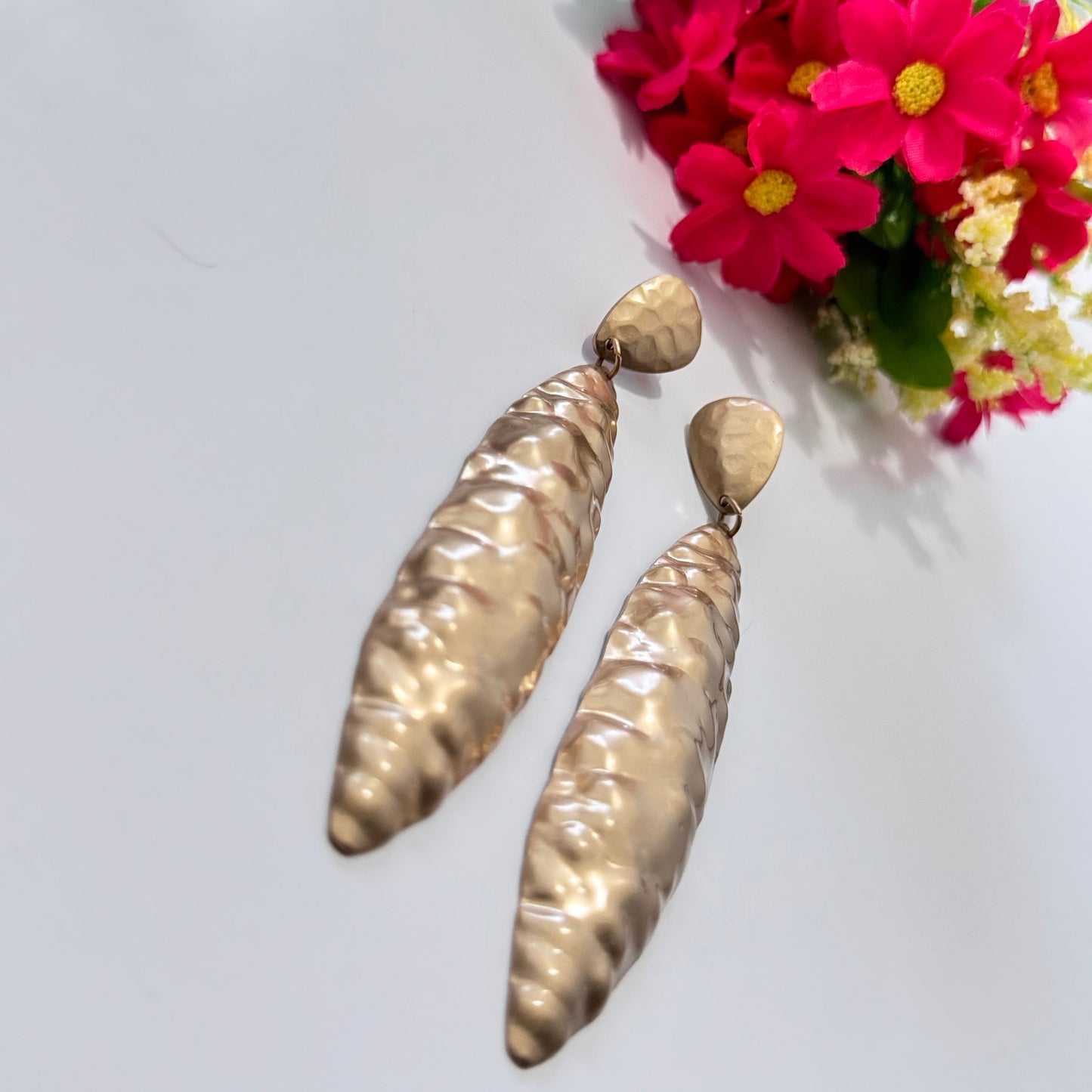 Elevate your style with these striking hammered gold statement earrings, designed to captivate and command attention. This elongated silhouette and textured finish create a stunning interplay of light and shadow, ensuring it shimmer with every movement.