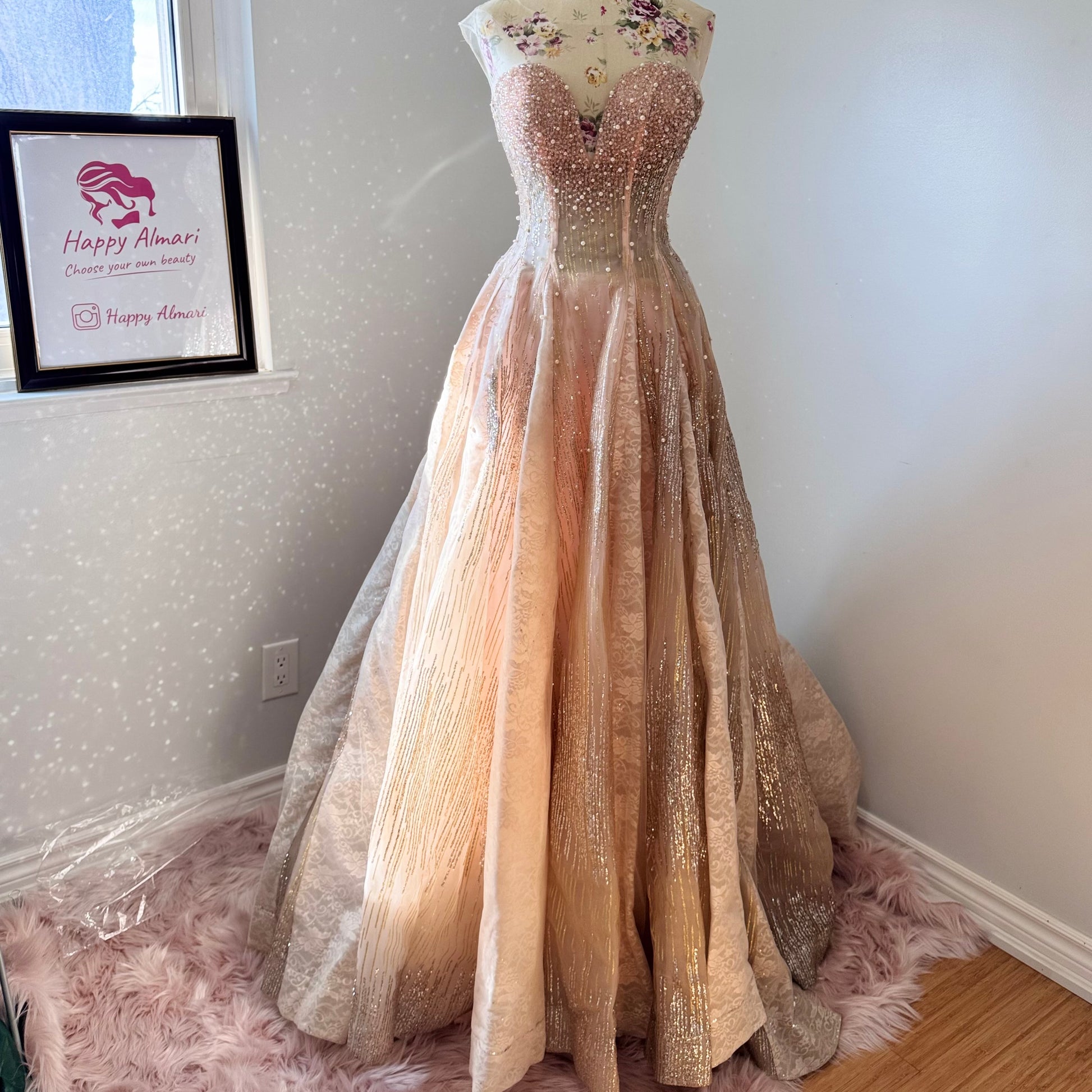 The dress in the image is an elegant, heavily embellished gown with a fitted bodice and a voluminous skirt. It features intricate beadwork and embroidery, giving it a luxurious and opulent look. The sheer illusion neckline adds a delicate touch, while the structured, corset-like bodice enhances the silhouette. The fabric appears to be thick and richly adorned, making the dress quite heavy. The overall design exudes a regal and glamorous feel, perfect for a formal event or gala.