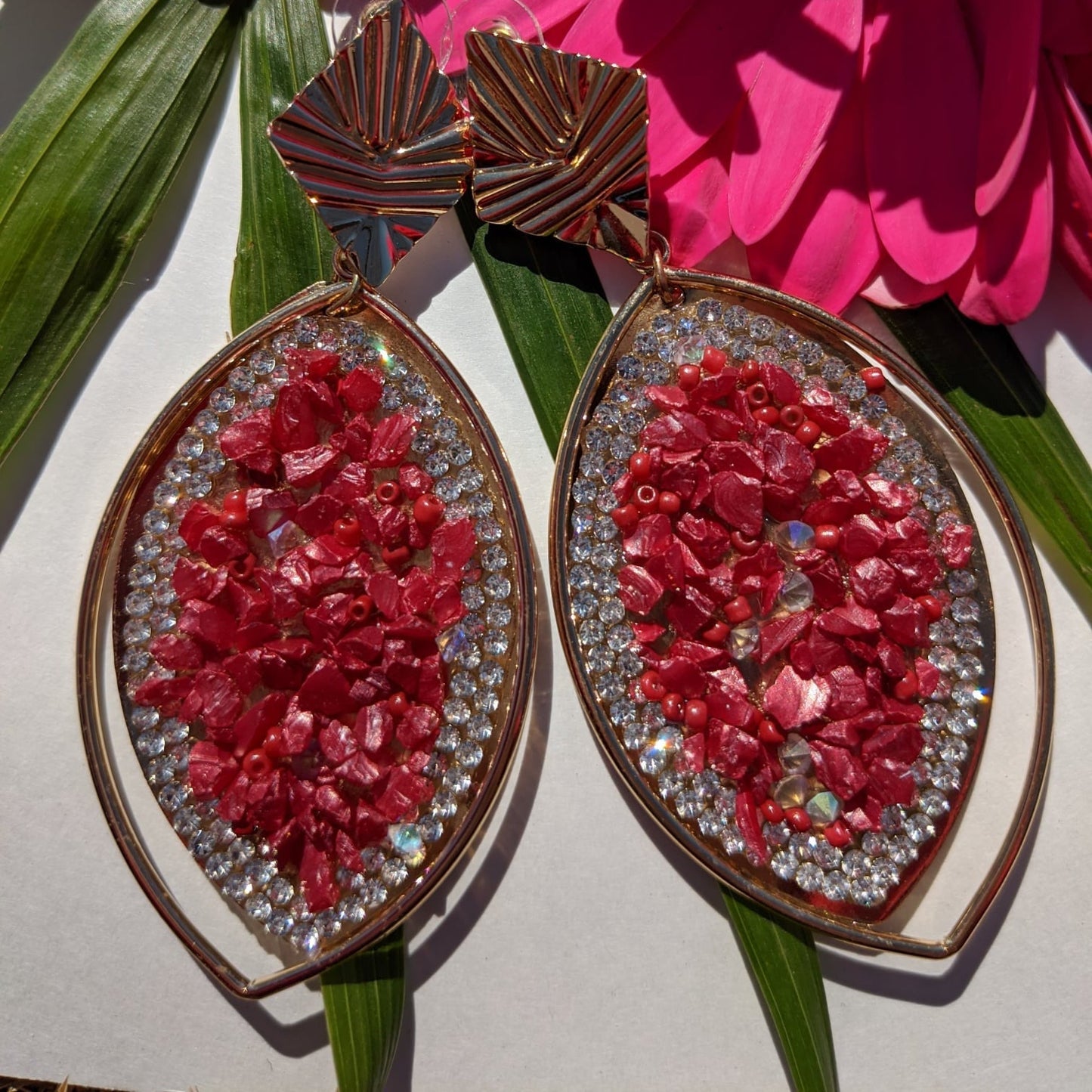 A perfect blend of luxury and elegance! These eye-catching earrings feature a stunning marquise-shaped design, adorned with&nbsp;crimson-red gemstone chips, dazzling rhinestones, and a sleek gold-tone frame that exudes sophistication. The unique geometric gold accents add a modern touch, making them the perfect accessory for fashion-forward women who love to stand out. Whether you're dressing up for a glamorous evening, a festive celebration, or adding a bold touch to your everyday look.