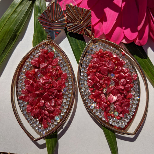 A perfect blend of luxury and elegance! These eye-catching earrings feature a stunning marquise-shaped design, adorned with&nbsp;crimson-red gemstone chips, dazzling rhinestones, and a sleek gold-tone frame that exudes sophistication. The unique geometric gold accents add a modern touch, making them the perfect accessory for fashion-forward women who love to stand out. Whether you're dressing up for a glamorous evening, a festive celebration, or adding a bold touch to your everyday look.