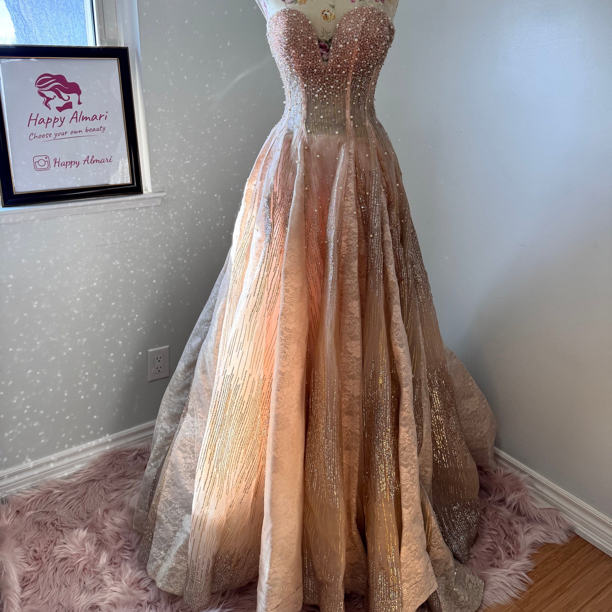 The dress is an elegant, heavily embellished gown with a fitted bodice and a voluminous skirt. It features intricate beadwork and embroidery, giving it a luxurious and opulent look. The sheer illusion neckline adds a delicate touch, while the structured, corset-like bodice enhances the silhouette. The fabric appears to be thick and richly adorned, making the dress quite heavy. The overall design exudes a regal and glamorous feel, perfect for a formal event or gala.