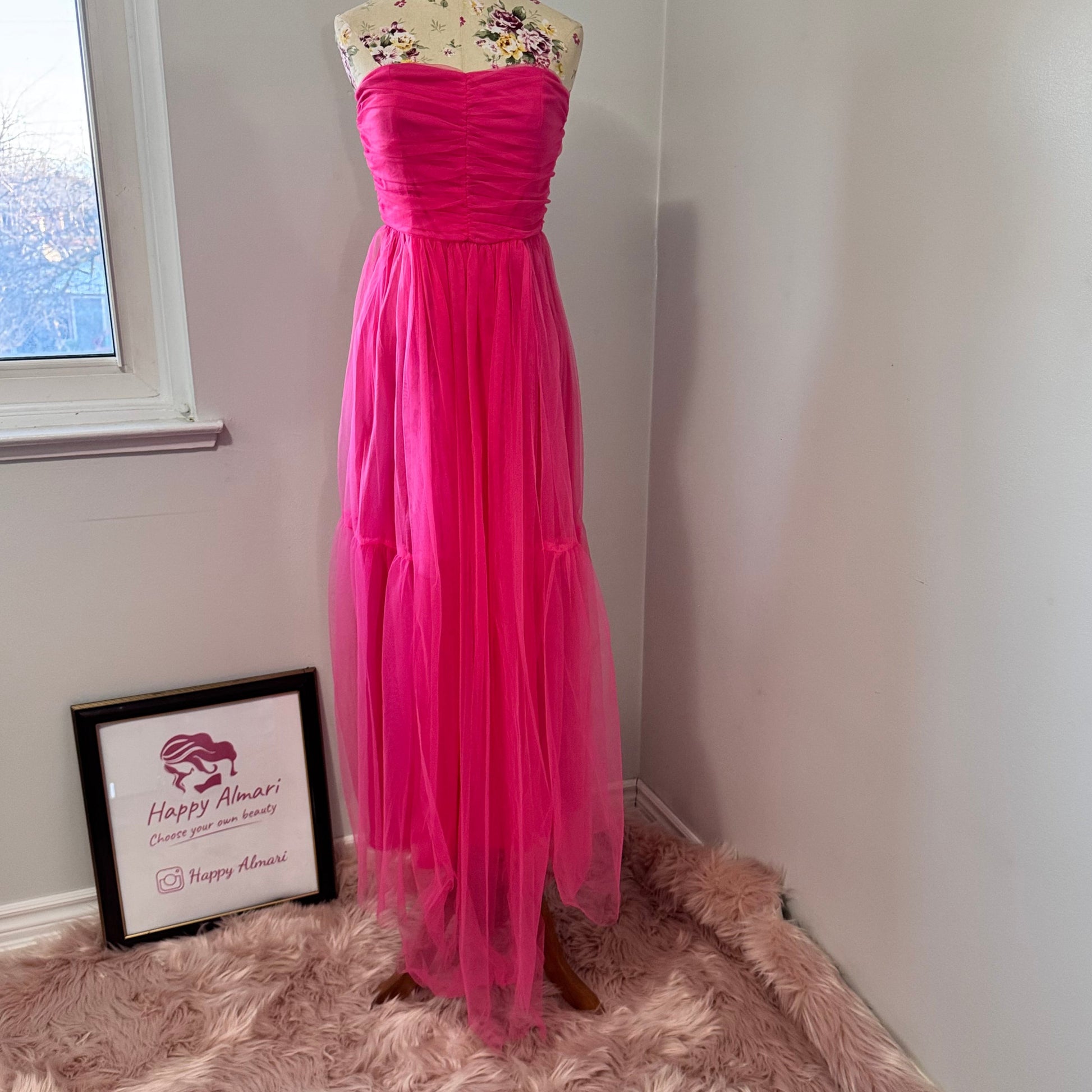 Turn heads and steal the spotlight in this breathtaking hot pink tulle gown, designed for those who dare to stand out. Featuring a strapless ruched bodice that flatters every curve and a flowing layered tulle skirt that moves with elegance, this dress is the ultimate statement piece for proms, weddings, gala nights, or any special occasion. The vibrant color radiates confidence and charm, making you the center of attention wherever you go. 