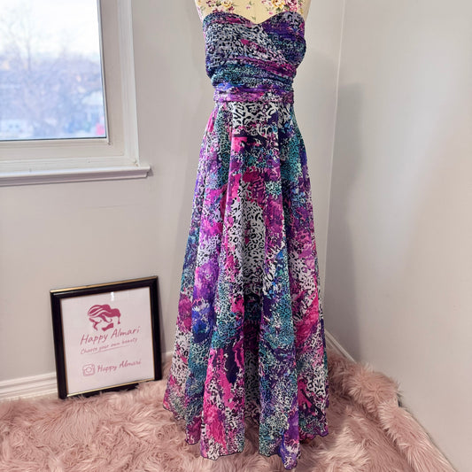 Unleash your bold, vibrant spirit with this breathtaking strapless gown, a mesmerizing fusion of art and fashion. Designed to turn heads, this flowing masterpiece features an explosion of rich purples, electric blues, and striking pinks in a captivating abstract animal print. The ruched bodice flatters the silhouette, while the voluminous skirt cascades effortlessly, creating a dreamy, ethereal effect with every step. 
