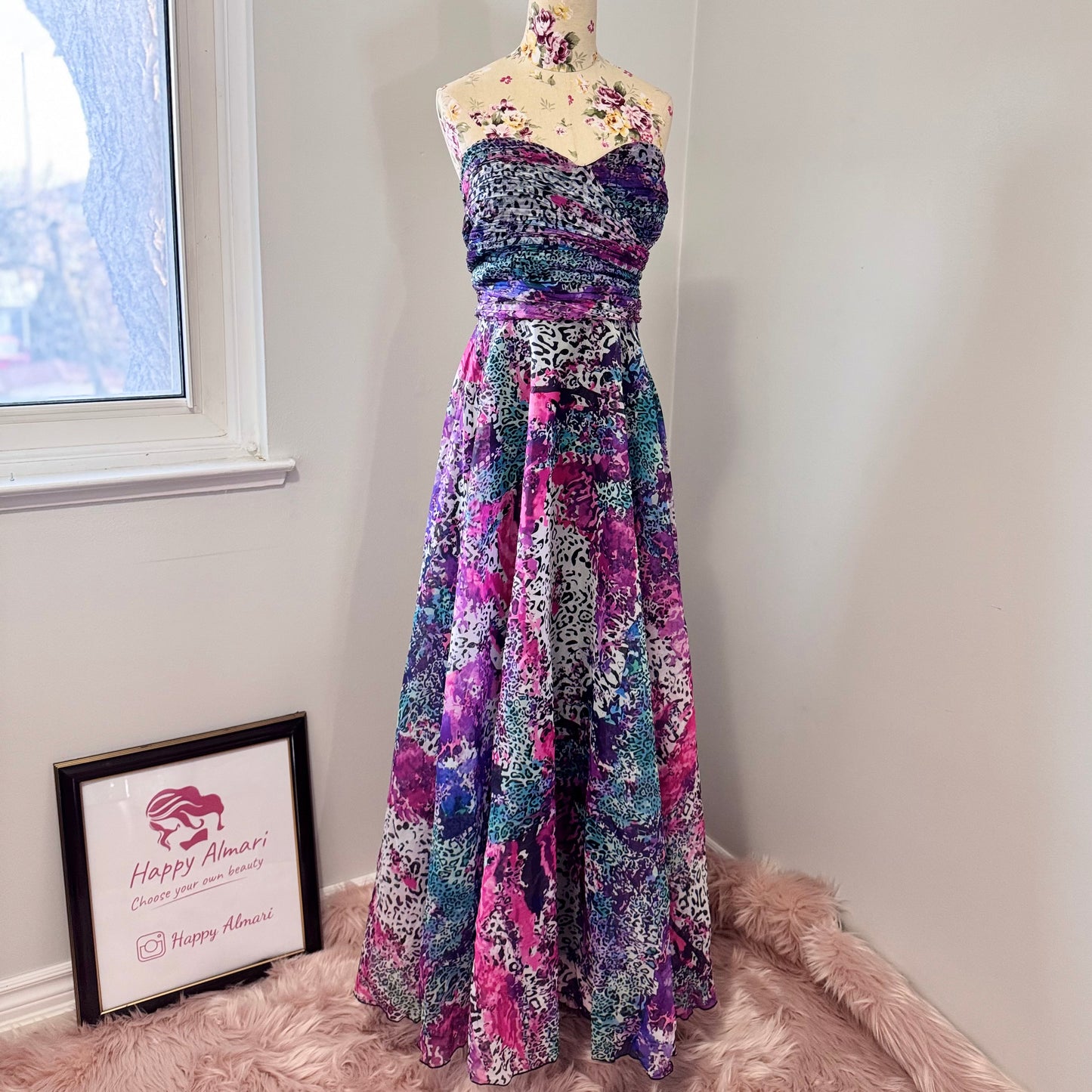 Unleash your bold, vibrant spirit with this breathtaking strapless gown, a mesmerizing fusion of art and fashion. Designed to turn heads, this flowing masterpiece features an explosion of rich purples, electric blues, and striking pinks in a captivating abstract animal print. The ruched bodice flatters the silhouette, while the voluminous skirt cascades effortlessly, creating a dreamy, ethereal effect with every step. 