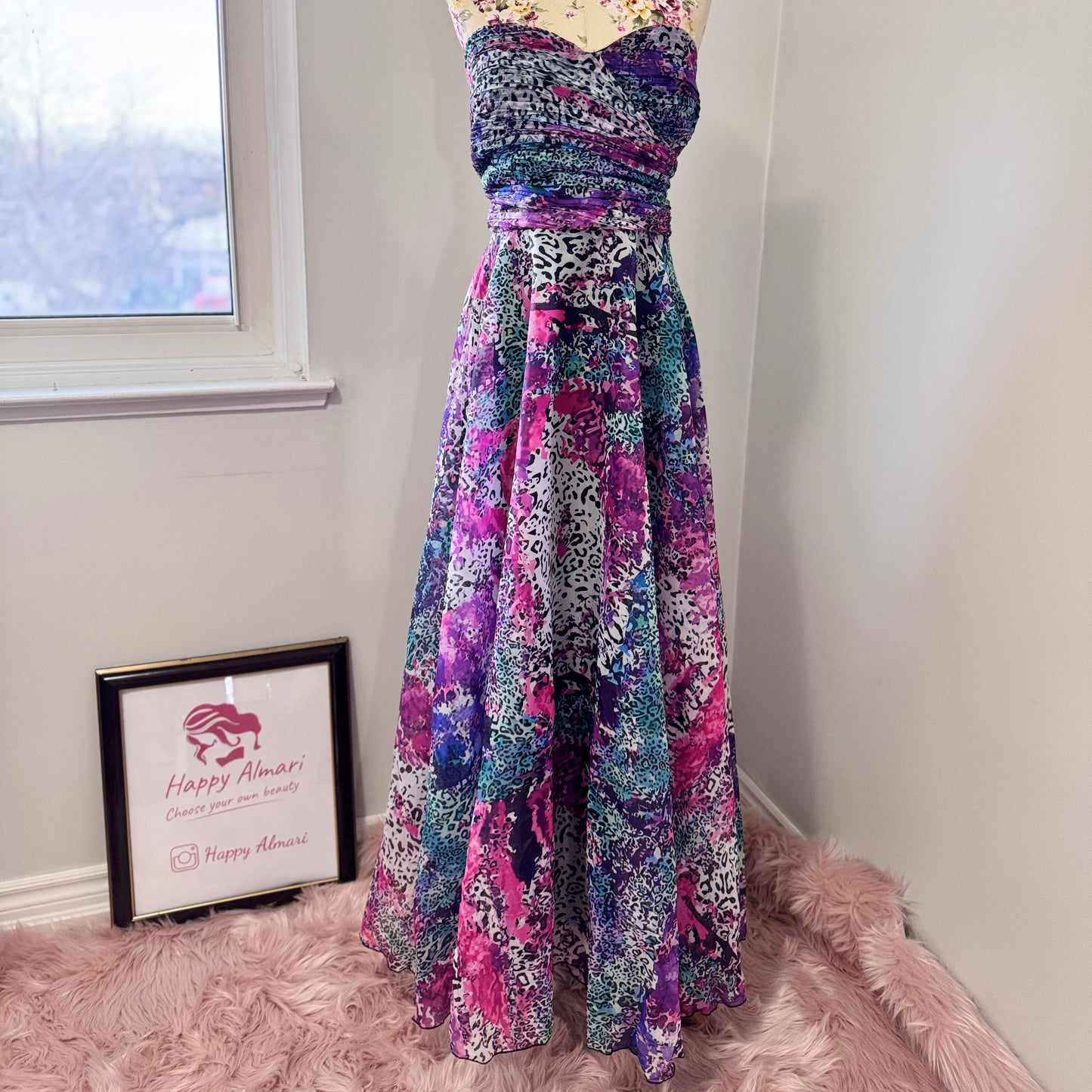 Unleash your bold, vibrant spirit with this breathtaking strapless gown, a mesmerizing fusion of art and fashion. Designed to turn heads, this flowing masterpiece features an explosion of rich purples, electric blues, and striking pinks in a captivating abstract animal print. The ruched bodice flatters the silhouette, while the voluminous skirt cascades effortlessly, creating a dreamy, ethereal effect with every step. 