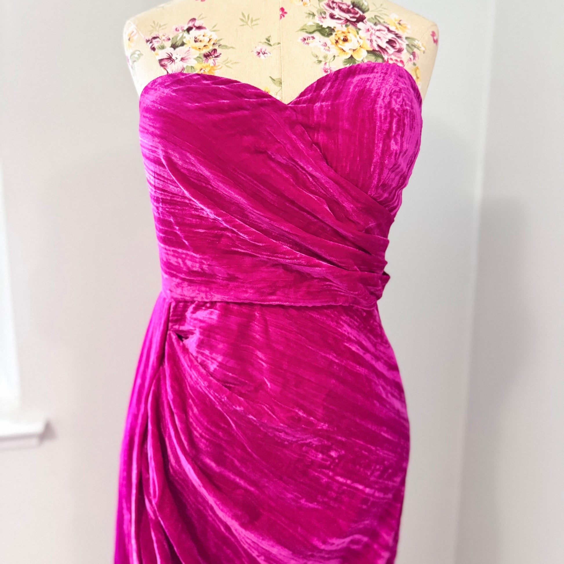 Turn heads in this stunning fuchsia velvet gown, designed to exude confidence and effortless glamour. Featuring a sculpted sweetheart neckline and expertly draped fabric that cinches at the waist, this dress enhances your natural silhouette with a flattering fit. The asymmetrical ruched detailing cascades into a flowing side drape, adding movement and dimension for a show-stopping effect.