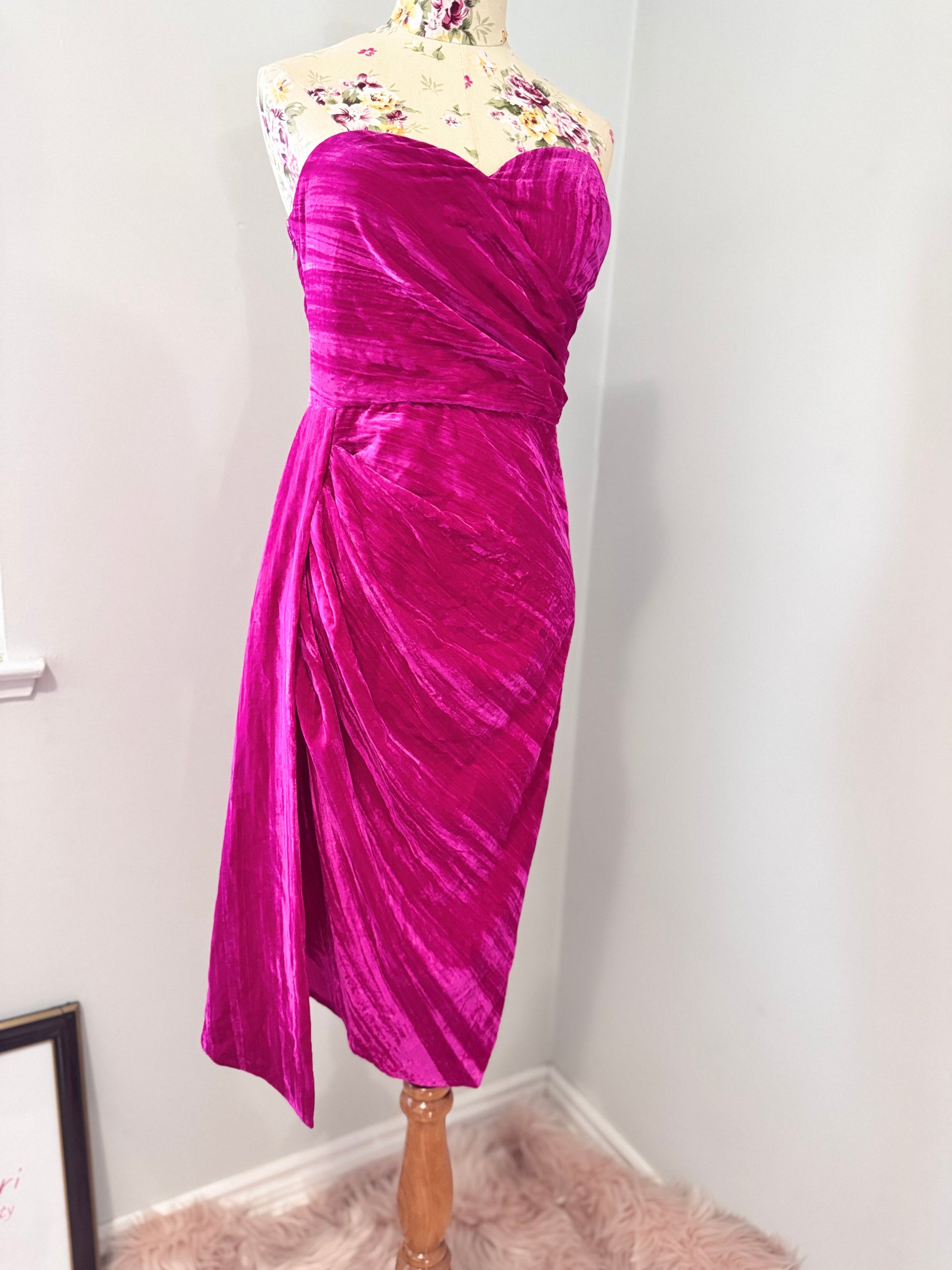 Turn heads in this stunning fuchsia velvet gown, designed to exude confidence and effortless glamour. Featuring a sculpted sweetheart neckline and expertly draped fabric that cinches at the waist, this dress enhances your natural silhouette with a flattering fit. The asymmetrical ruched detailing cascades into a flowing side drape, adding movement and dimension for a show-stopping effect.