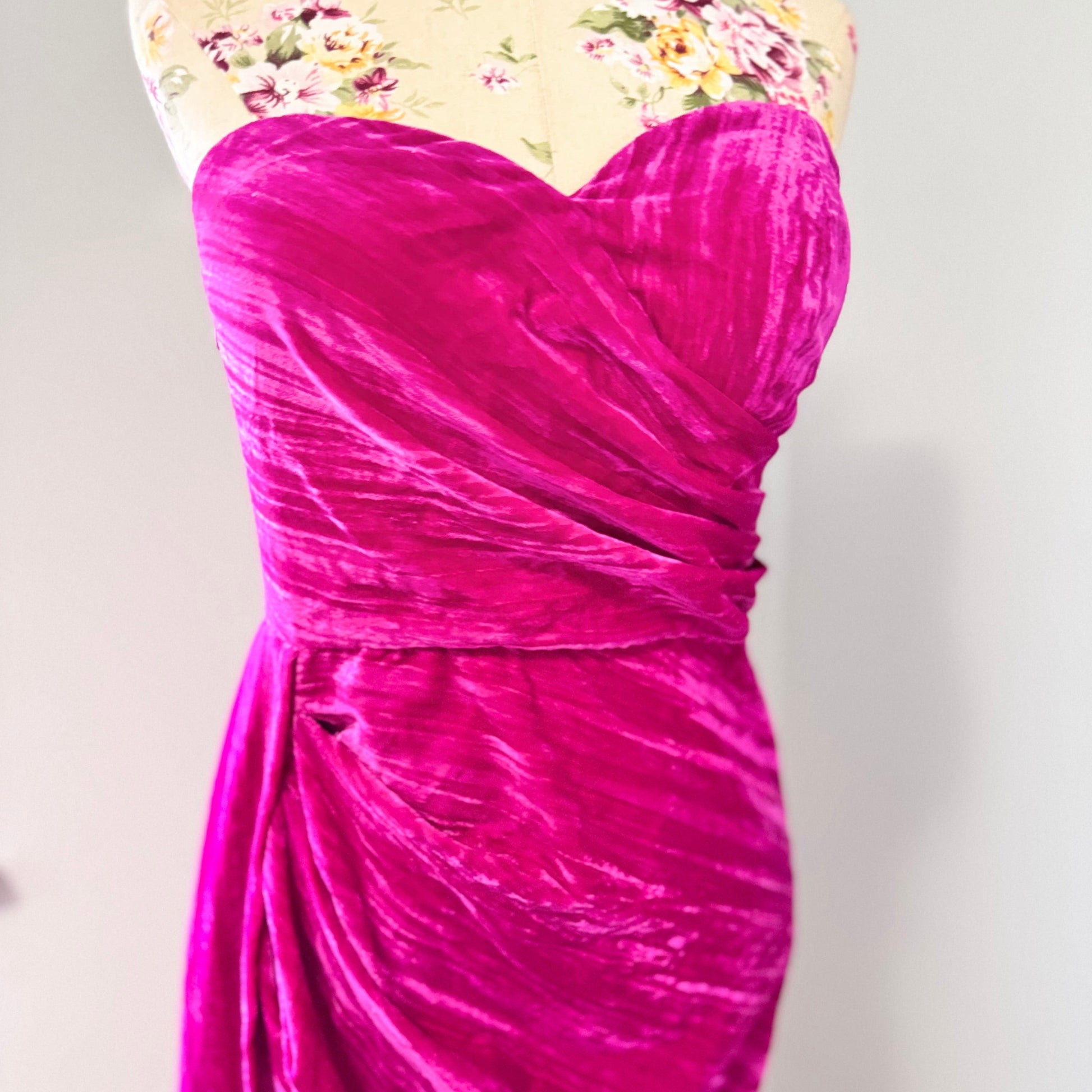 Turn heads in this stunning fuchsia velvet gown, designed to exude confidence and effortless glamour. Featuring a sculpted sweetheart neckline and expertly draped fabric that cinches at the waist, this dress enhances your natural silhouette with a flattering fit. The asymmetrical ruched detailing cascades into a flowing side drape, adding movement and dimension for a show-stopping effect.
