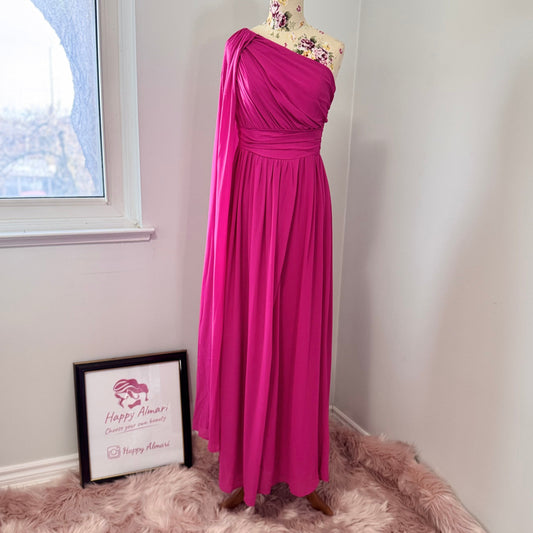 Step into effortless elegance with this breathtaking fuchsia one-shoulder gown, designed to make a statement at any event. Featuring a gracefully draped sleeve that cascades like a flowing waterfall, this dress exudes confidence, sophistication, and timeless charm. The cinched waist enhances your silhouette, while the soft, flowing fabric moves beautifully with every step.