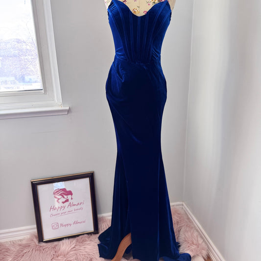 Step into timeless elegance with this breathtaking previously cherished royal blue velvet evening gown, designed to turn heads at any event. Crafted from rich, ultra-soft velvet, this figure-hugging masterpiece features a structured corset bodice with delicate pleated detailing that accentuates your silhouette. The sweetheart neckline adds a touch of romance, while the flowing skirt with a sultry thigh-high slit creates the perfect balance of sophistication and allure. In perfect condition.