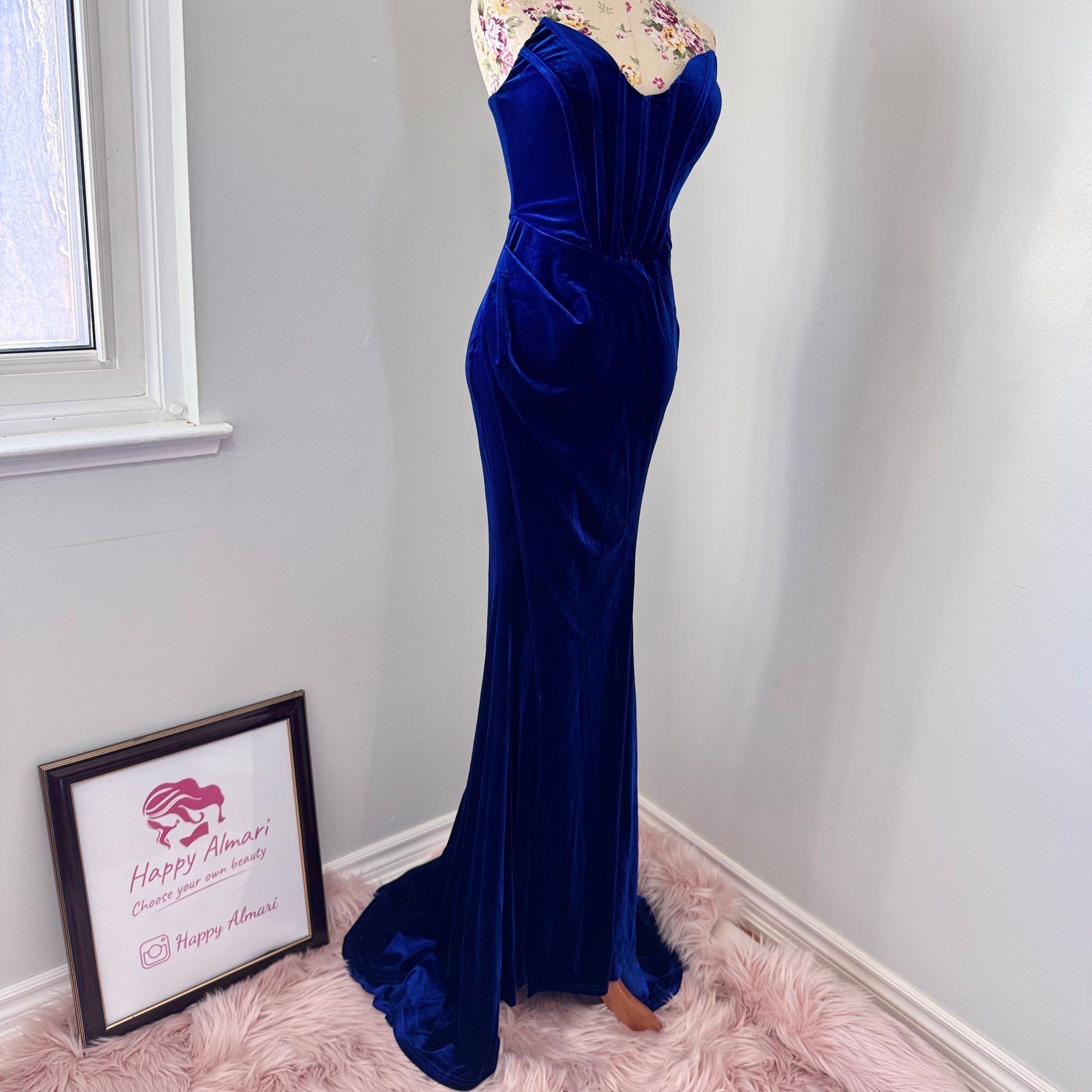 Step into timeless elegance with this breathtaking previously cherished royal blue velvet evening gown, designed to turn heads at any event. Crafted from rich, ultra-soft velvet, this figure-hugging masterpiece features a structured corset bodice with delicate pleated detailing that accentuates your silhouette. The sweetheart neckline adds a touch of romance, while the flowing skirt with a sultry thigh-high slit creates the perfect balance of sophistication and allure. In perfect condition.