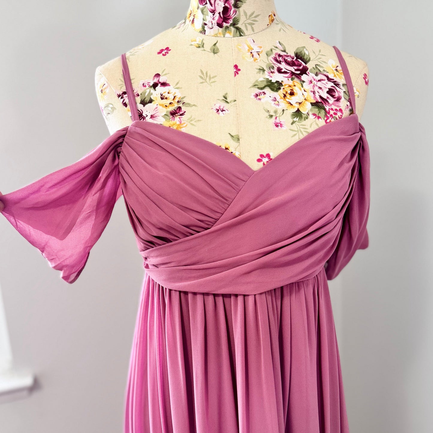 Turn heads with this stunning gently worn dusty rose evening gown that’s in perfect condition—a true blend of elegance and romance! Designed with a flattering ruched bodice, a flowing A-line skirt, and delicate off-the-shoulder draped sleeves, this dress is the epitome of timeless beauty. 