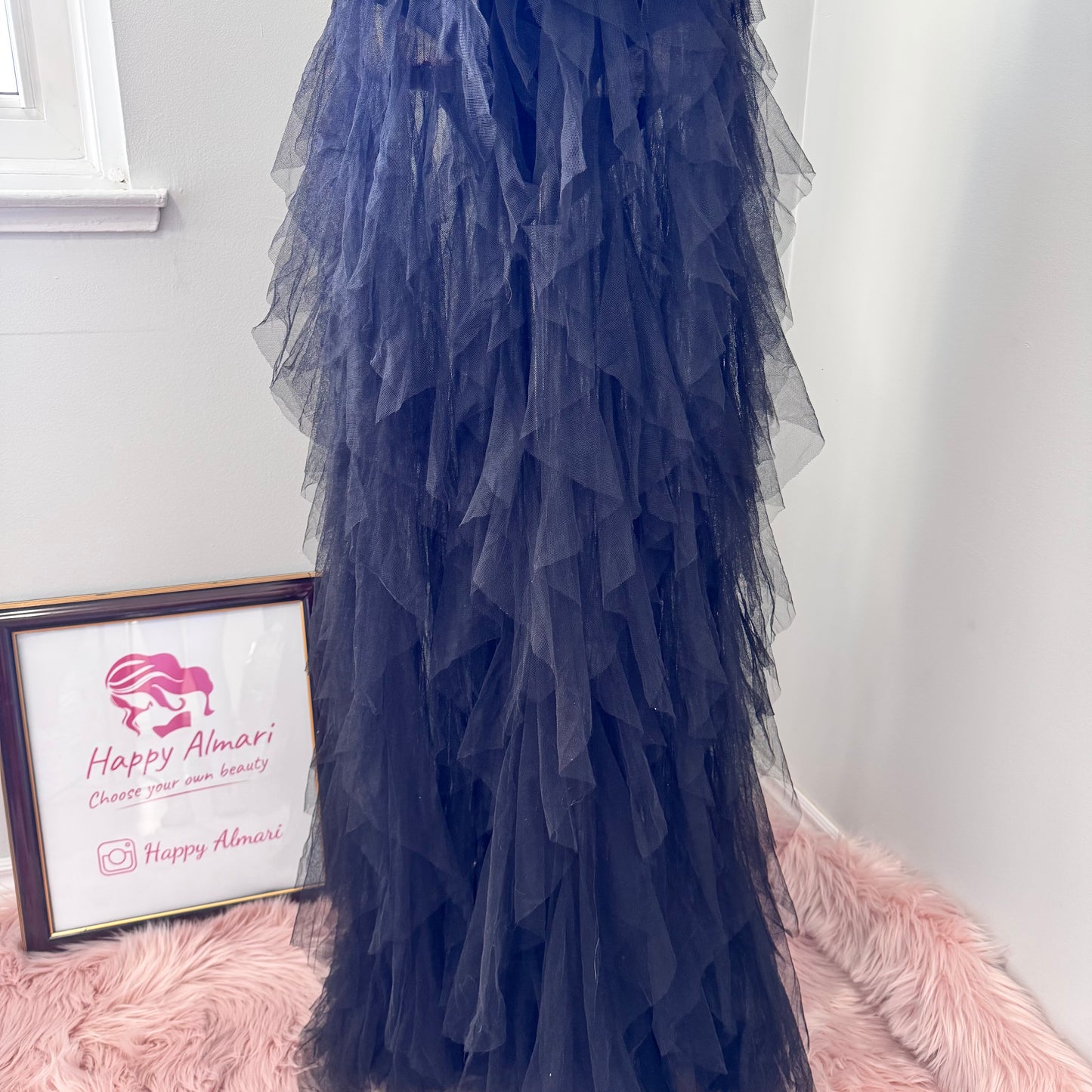 Introducing an black tulle gown that exudes timeless sophistication and drama. Featuring a structured, deep V-cut bodice that enhances the silhouette, this piece is designed with a sleek bodysuit bottom for a flawless, sculpted fit. The fitted waistline flows into cascading layers of soft, ruffled tulle, creating a breathtaking, ethereal effect with every step. This beautifully rehomed gown carries a story of style and elegance, ready to be cherished by its next wearer.