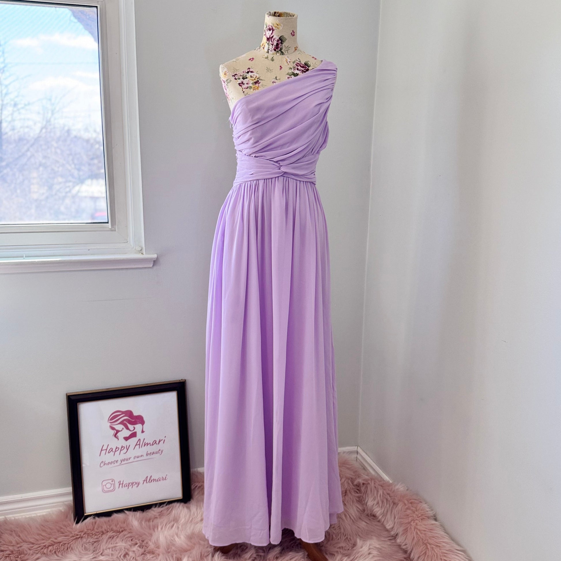 Turn heads in this breathtaking one-shoulder lavender gown, designed to make a statement at weddings, proms, and special occasions. Crafted with delicate pleated draping, a cinched waist for a flattering silhouette, and an elegant flowing skirt, this dress exudes timeless charm. Its soft, ethereal chiffon fabric creates a dreamy and romantic look.