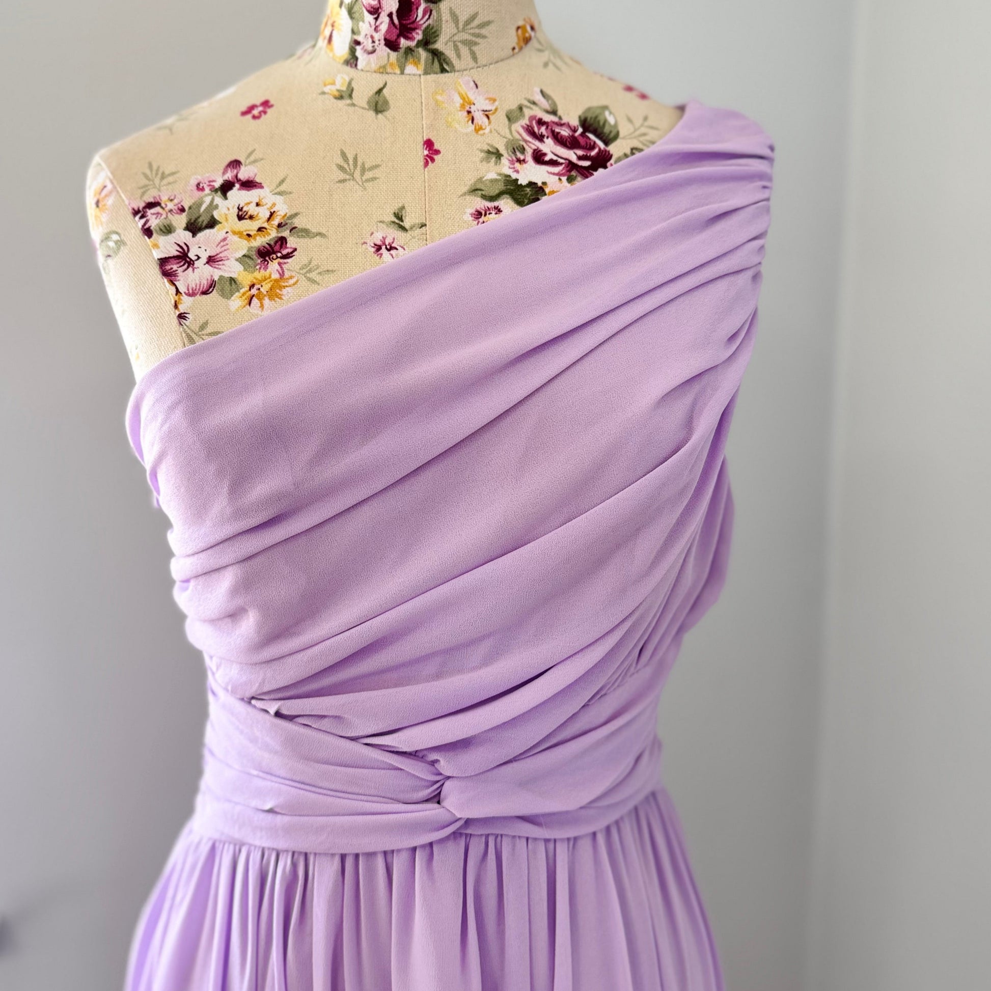 Turn heads in this breathtaking one-shoulder lavender gown, designed to make a statement at weddings, proms, and special occasions. Crafted with delicate pleated draping, a cinched waist for a flattering silhouette, and an elegant flowing skirt, this dress exudes timeless charm. Its soft, ethereal chiffon fabric creates a dreamy and romantic look.