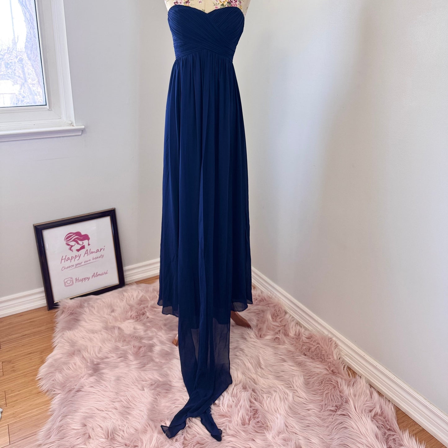 Elevate your elegance with this breathtaking navy-blue strapless evening gown, designed to make a statement at any special occasion. Featuring a flattering sweetheart neckline and a beautifully flowing chiffon skirt with a dramatic floor-length train, this dress exudes timeless sophistication. The structured bodice provides a secure fit, while the soft pleats add a touch of effortless charm. 