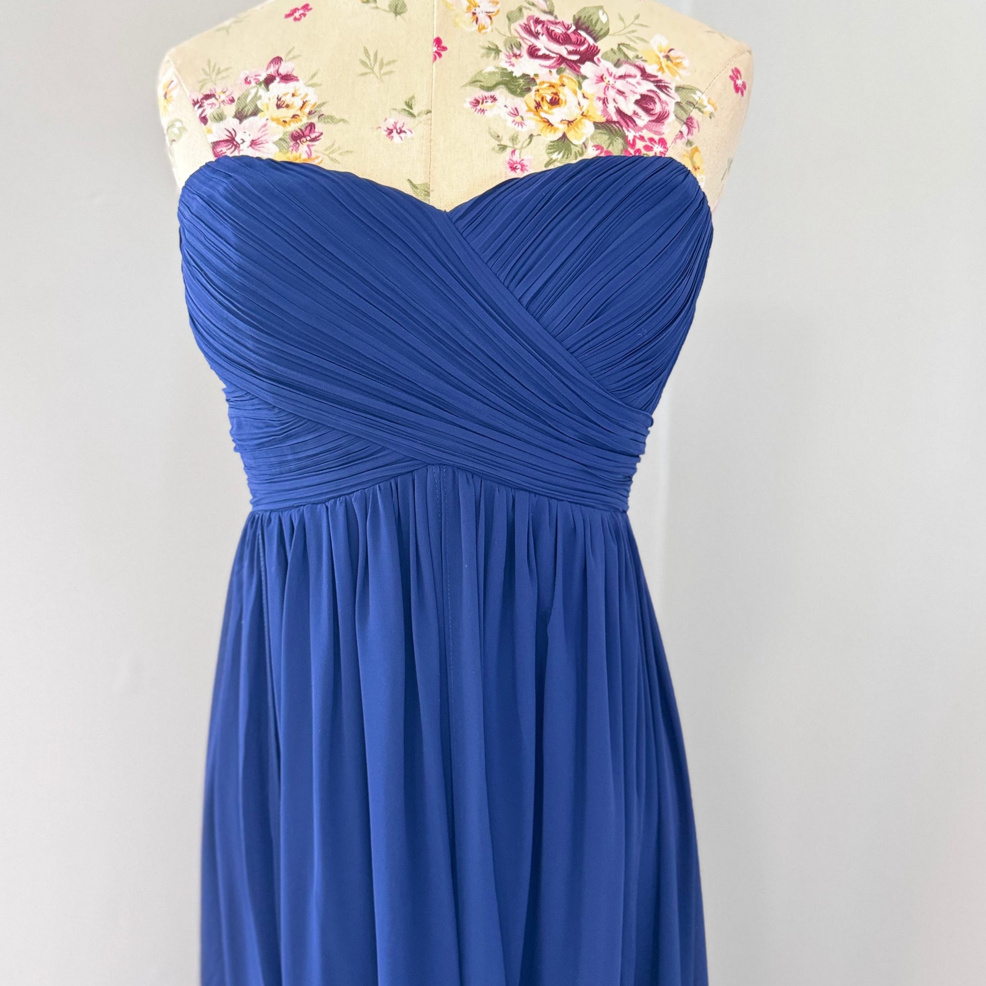 Elevate your elegance with this breathtaking navy-blue strapless evening gown, designed to make a statement at any special occasion. Featuring a flattering sweetheart neckline and a beautifully flowing chiffon skirt with a dramatic floor-length train, this dress exudes timeless sophistication. The structured bodice provides a secure fit, while the soft pleats add a touch of effortless charm. 