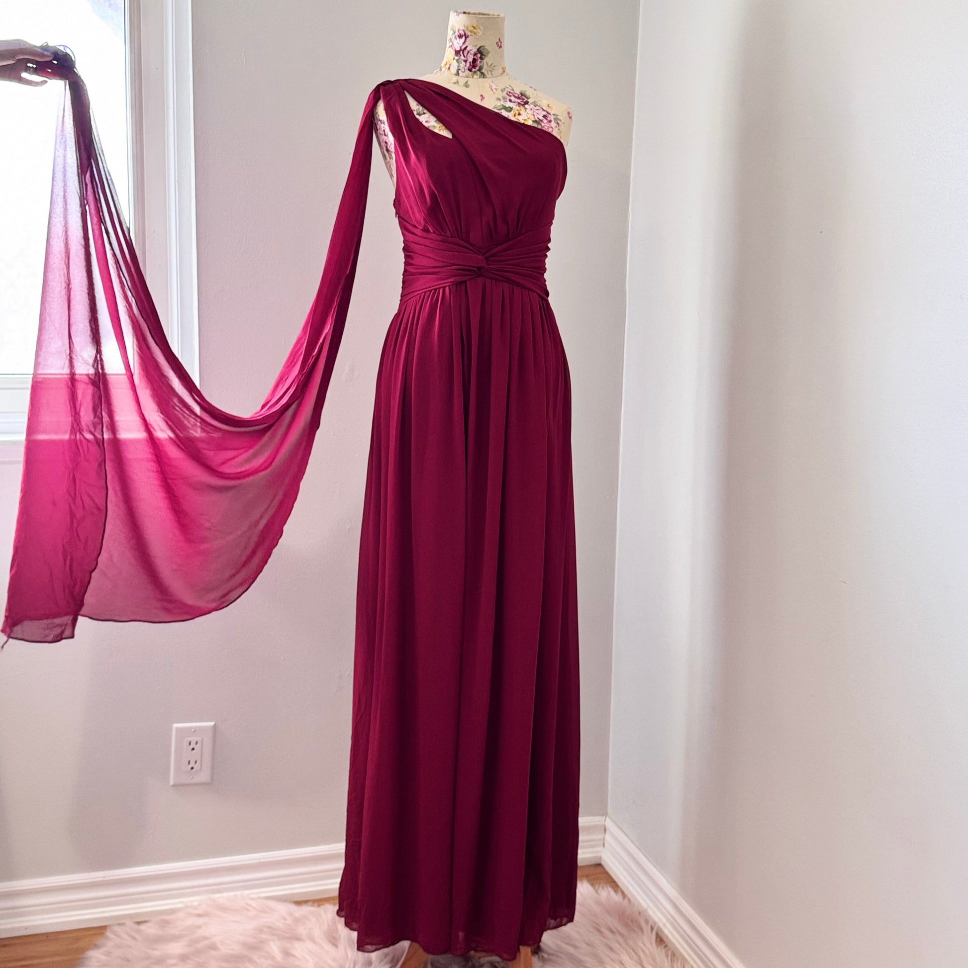 Elevate your wardrobe with this breathtaking one-shoulder gown in a deep wine hue, designed to make a statement at any formal event. Crafted from flowing chiffon, this dress drapes elegantly, featuring a cinched waist for a flattering silhouette and a striking sheer drape that adds an ethereal touch.