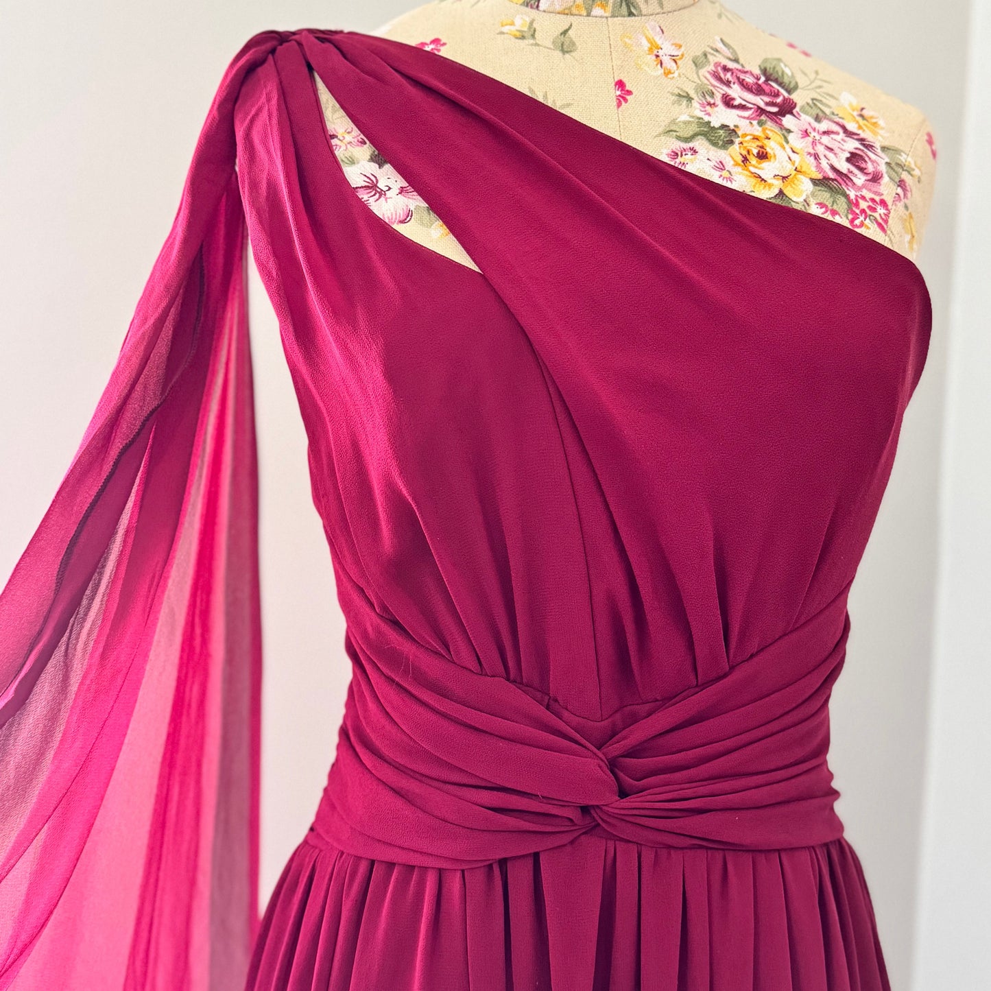 Elevate your wardrobe with this breathtaking one-shoulder gown in a deep wine hue, designed to make a statement at any formal event. Crafted from flowing chiffon, this dress drapes elegantly, featuring a cinched waist for a flattering silhouette and a striking sheer drape that adds an ethereal touch.