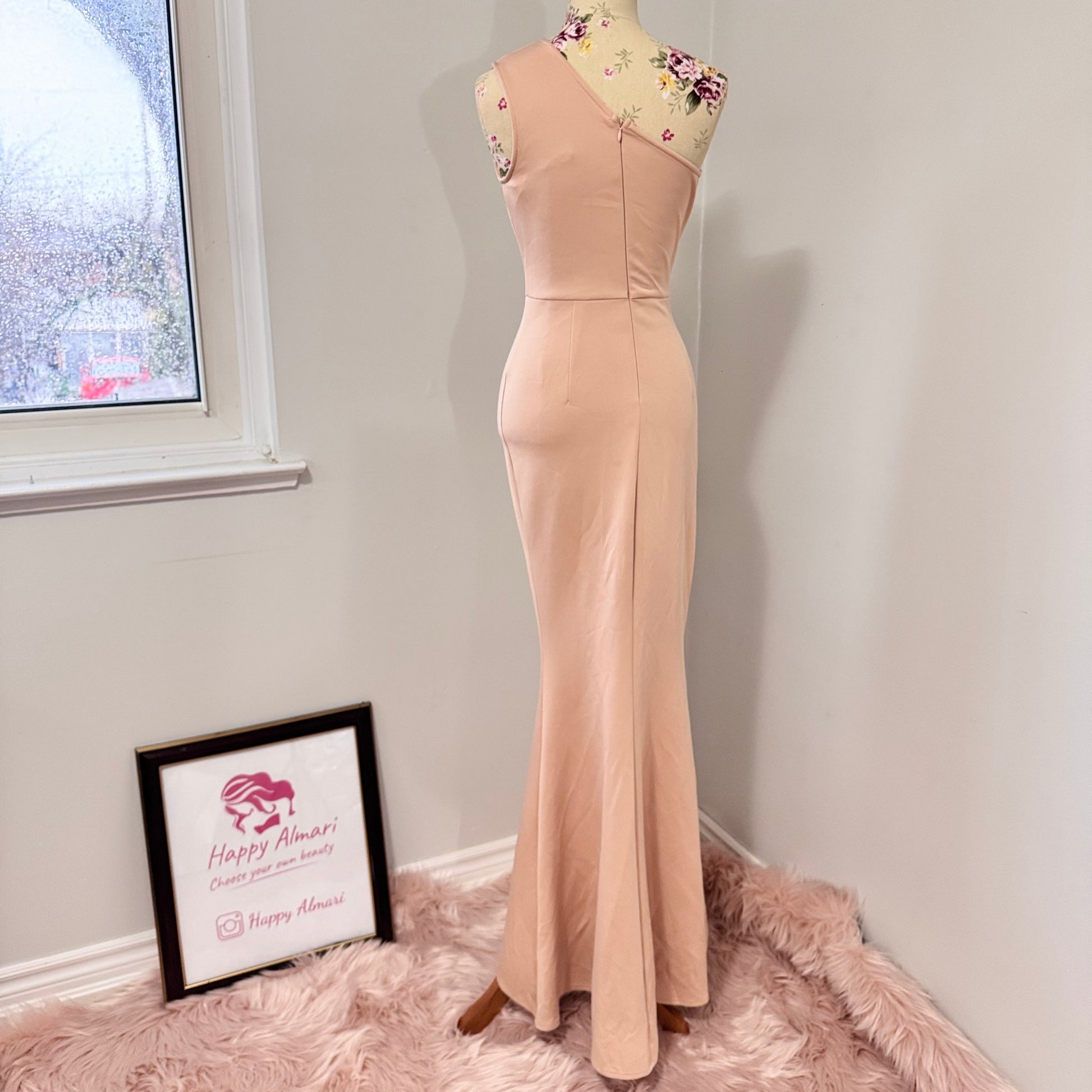 Make an unforgettable entrance in this stunning one-shoulder gown, designed to accentuate your curves with effortless grace. Featuring a sleek asymmetrical neckline and elegantly draped side ruching, this dress flatters from every angle. The high-slit detail adds just the right touch of allure, making it the perfect choice for weddings, formal events, or any special occasion where you want to shine. The soft blush hue complements a variety of skin tones, ensuring a timeless and sophisticated look. 