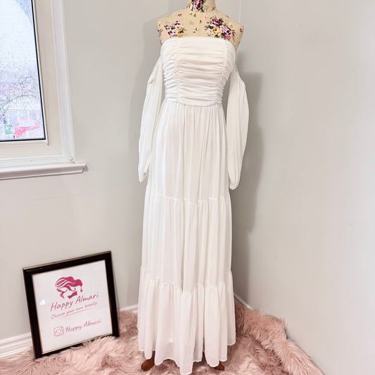 Step into effortless elegance with this stunning off-shoulder white maxi dress, designed to make you feel like a goddess at any event! Featuring a flattering ruched bodice, romantic flowy tiered skirt, and long billowy sleeves.