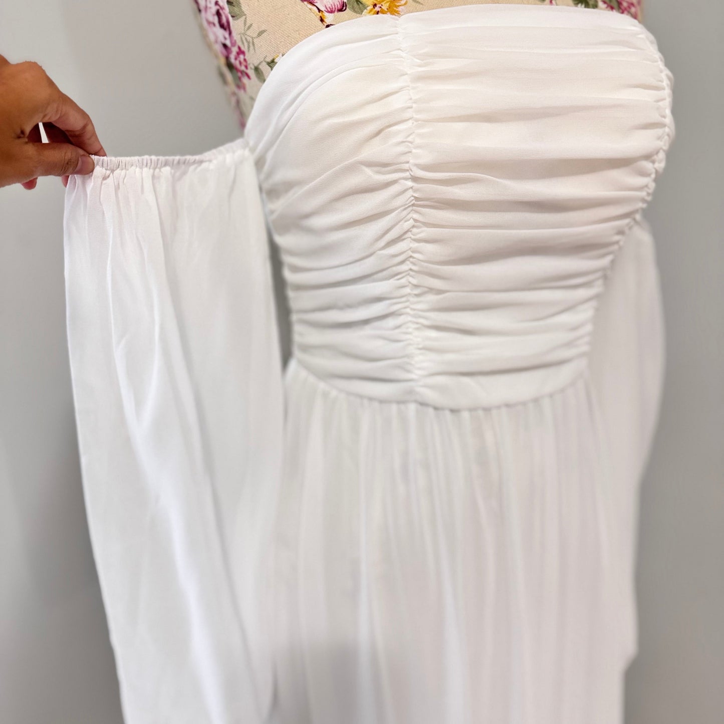 Step into effortless elegance with this stunning off-shoulder white maxi dress, designed to make you feel like a goddess at any event! Featuring a flattering ruched bodice, romantic flowy tiered skirt, and long billowy sleeves.