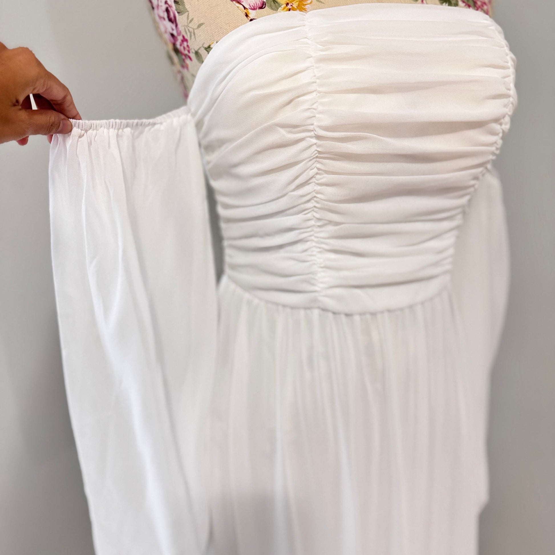 Step into effortless elegance with this stunning off-shoulder white maxi dress, designed to make you feel like a goddess at any event! Featuring a flattering ruched bodice, romantic flowy tiered skirt, and long billowy sleeves.