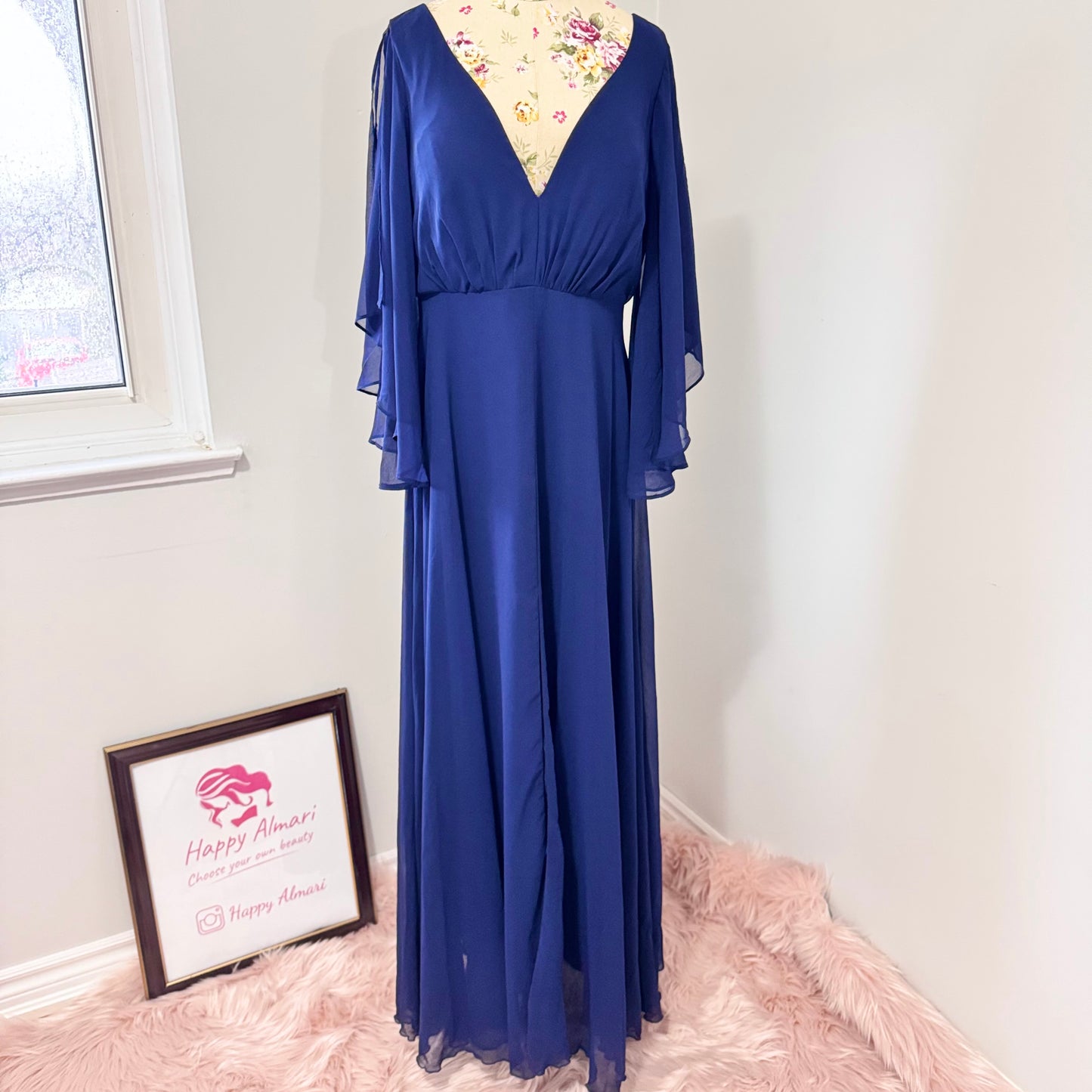 Turn heads in this stunning deep navy gown that radiates elegance and grace. Designed with a flowy chiffon overlay, a flattering cinched waist, and dreamy flutter sleeves, this dress is perfect for formal events, weddings, or special occasions. The deep V-neckline and subtle front slit add just the right touch of sophistication and allure. This gently cherished piece is in excellent condition, ready for a new owner to make unforgettable memories.