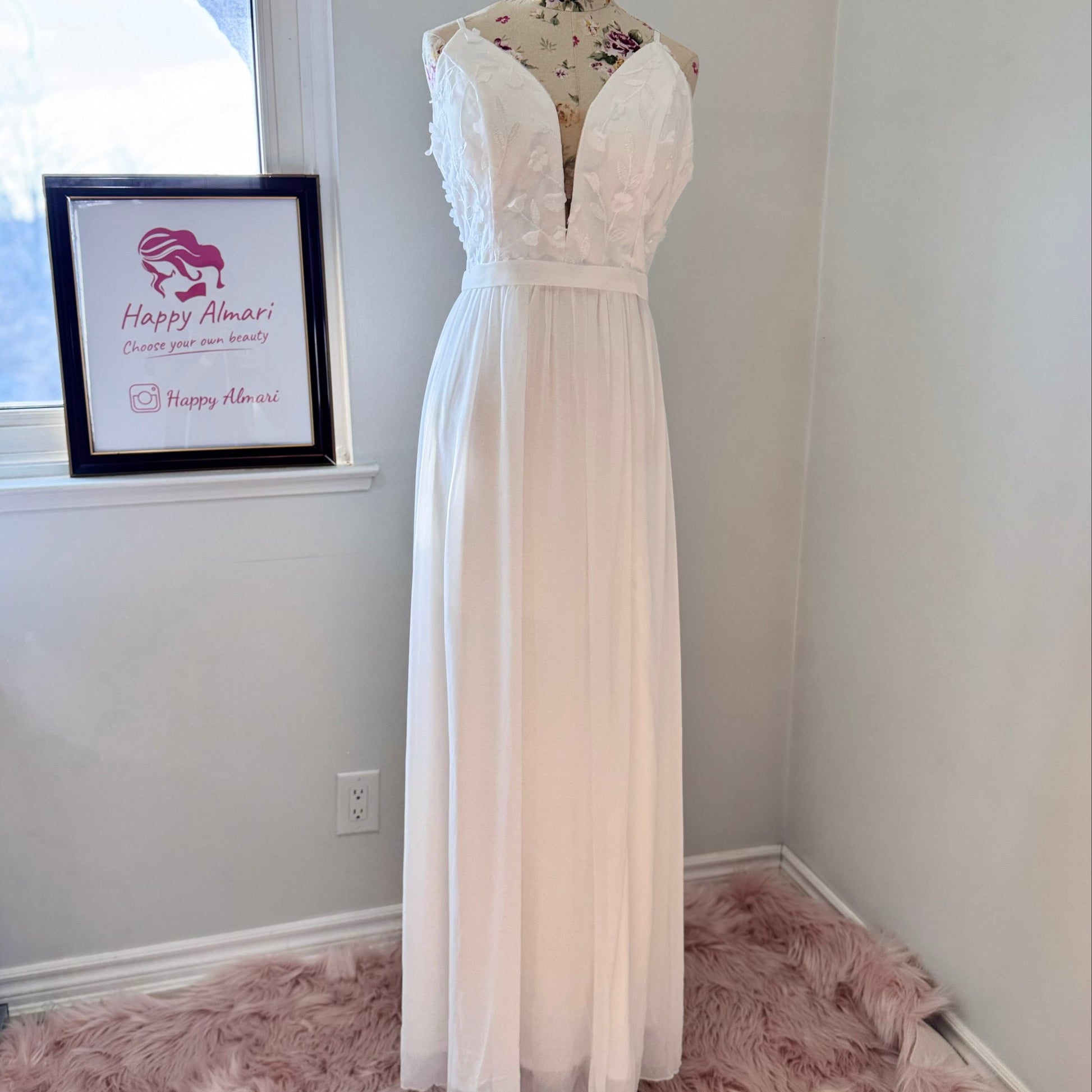 Elevate your style with this breathtaking white gown, designed to captivate with its effortless elegance and timeless charm. Featuring a flowy A-line silhouette, this dress showcases a delicate plunging V-neckline adorned with intricate 3D floral appliqués and embroidered leaf details, adding a soft, ethereal touch. The fitted bodice seamlessly transitions into a lightweight, flowing chiffon skirt, creating graceful movement with every step.