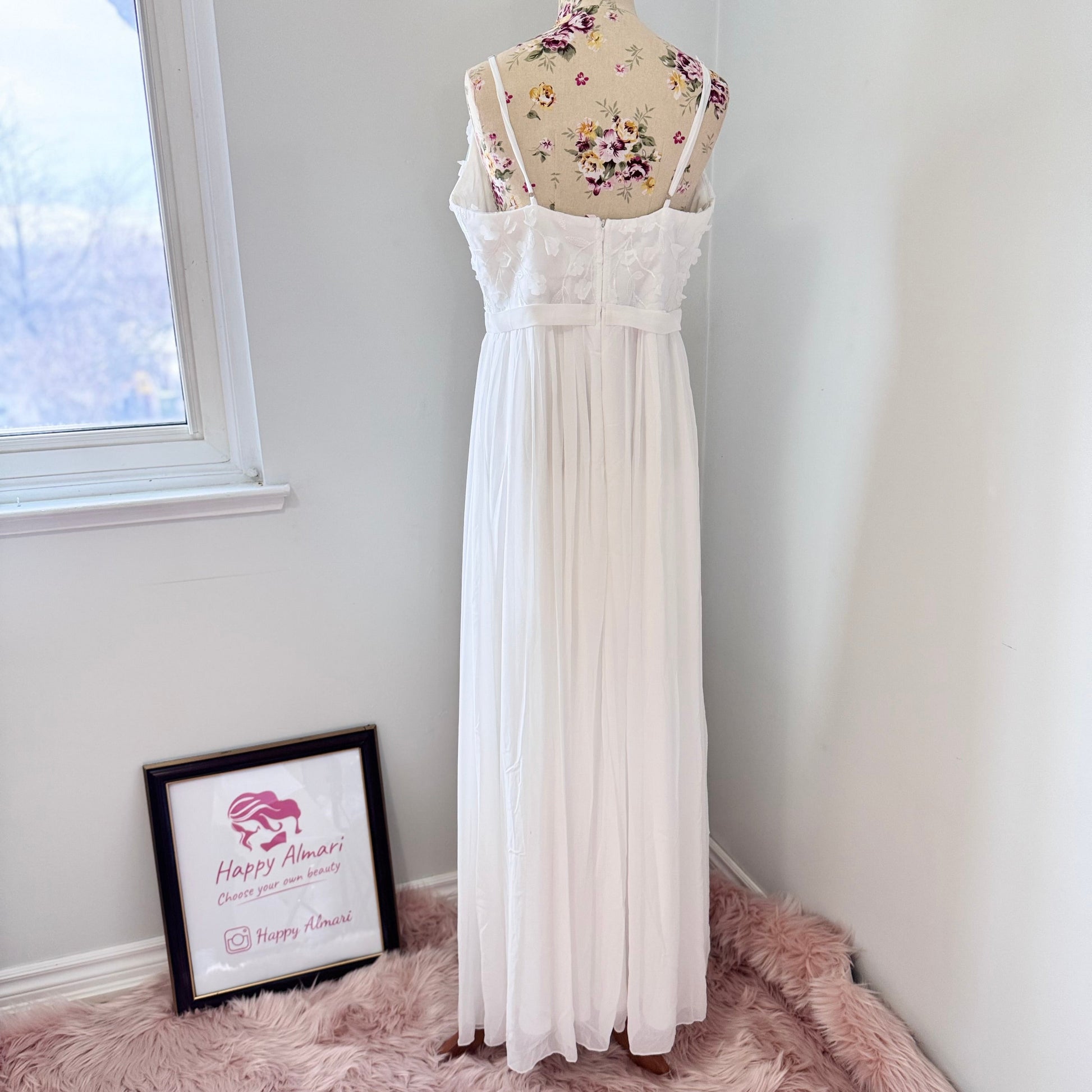 Elevate your style with this breathtaking white gown, designed to captivate with its effortless elegance and timeless charm. Featuring a flowy A-line silhouette, this dress showcases a delicate plunging V-neckline adorned with intricate 3D floral appliqués and embroidered leaf details, adding a soft, ethereal touch. The fitted bodice seamlessly transitions into a lightweight, flowing chiffon skirt, creating graceful movement with every step.