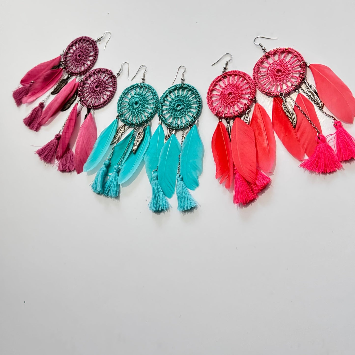 These intricately woven dreamcatcher-inspired earrings feature a stunning circular lace design, adorned with delicate feathers, silky tassels, and metallic leaf charms that sway beautifully with every movement.