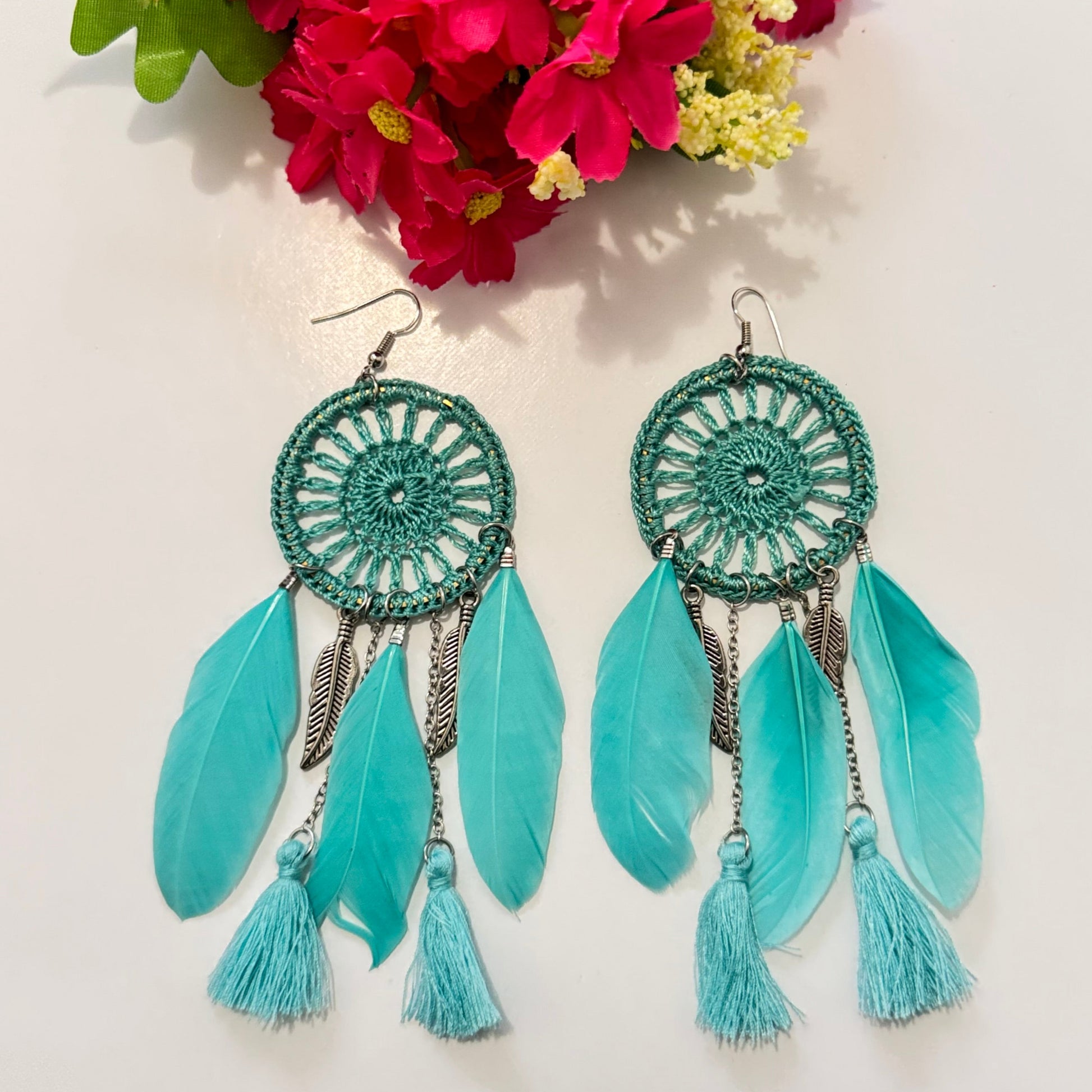 These intricately woven dreamcatcher-inspired earrings feature a stunning circular lace design, adorned with delicate feathers, silky tassels, and metallic leaf charms that sway beautifully with every movement.