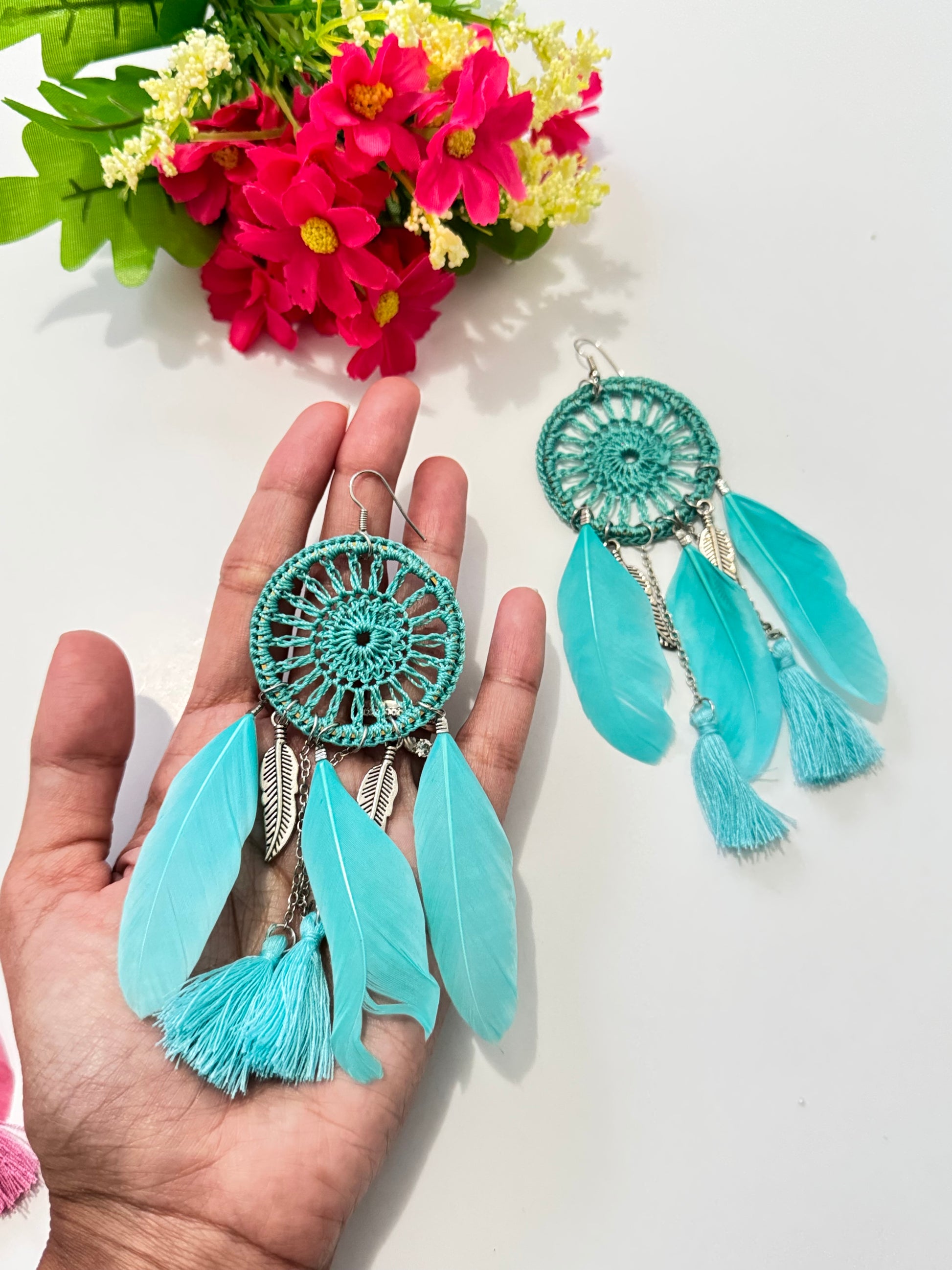 These intricately woven dreamcatcher-inspired earrings feature a stunning circular lace design, adorned with delicate feathers, silky tassels, and metallic leaf charms that sway beautifully with every movement.