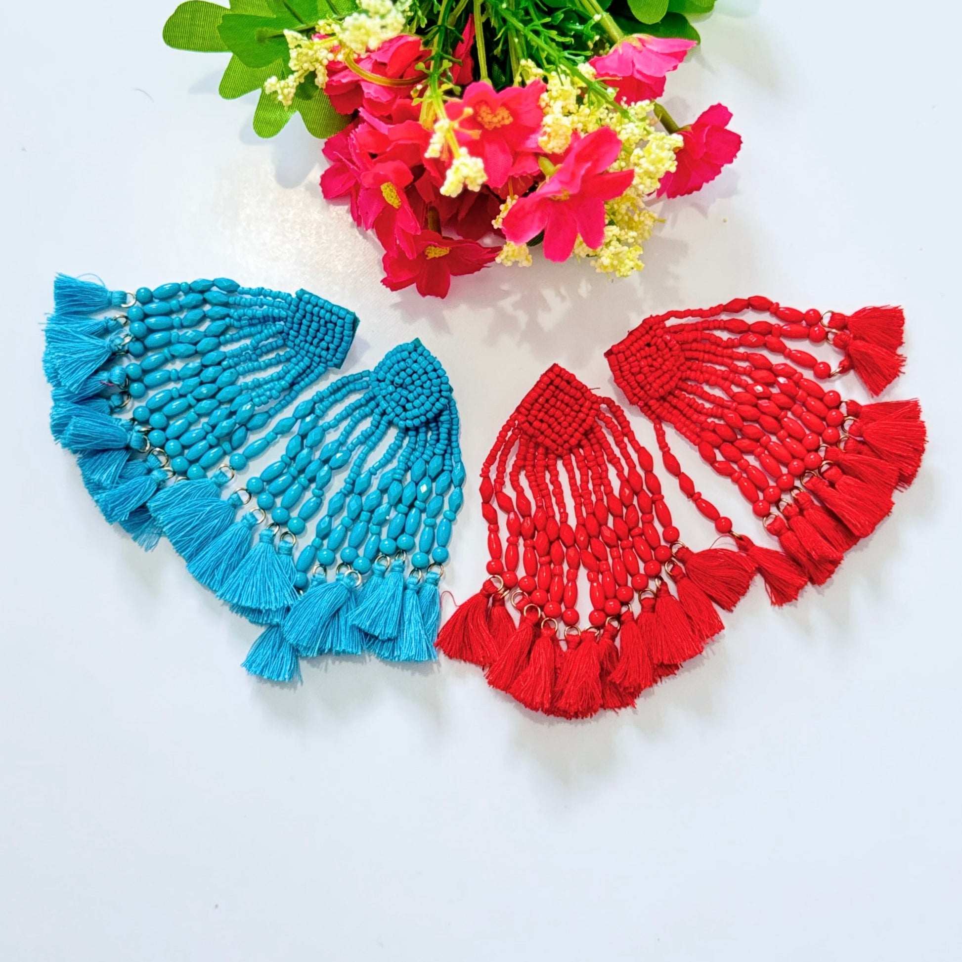  Crafted with intricate seed bead detailing and cascading strands of smooth, polished beads, these earrings exude a bold, eye-catching charm. The vibrant hues of turquoise and fiery red add a striking pop of color to any outfit, making them the perfect accessory for special occasions, beach vacations, or everyday glamour. 