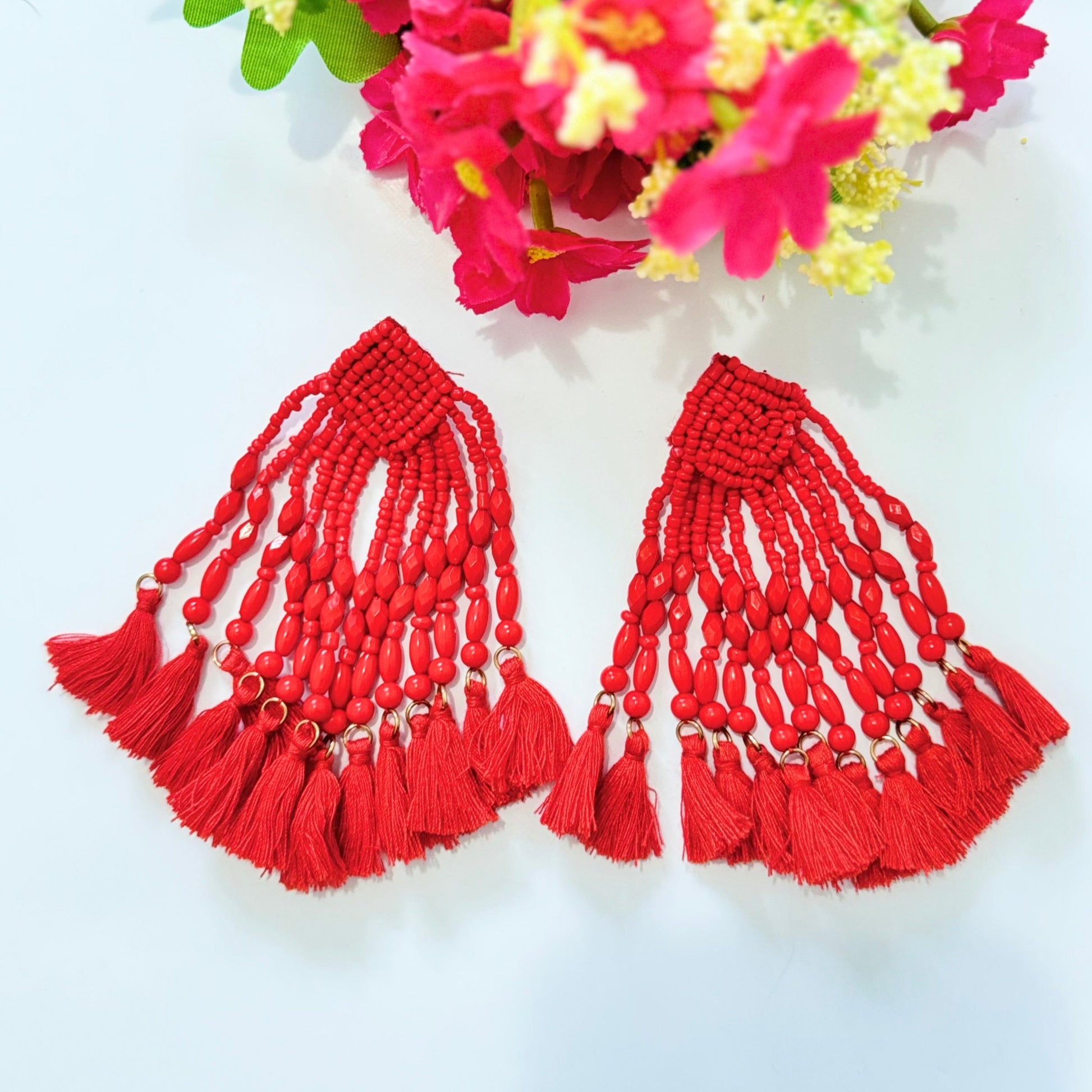  Crafted with intricate seed bead detailing and cascading strands of smooth, polished beads, these earrings exude a bold, eye-catching charm. The vibrant hues of turquoise and fiery red add a striking pop of color to any outfit, making them the perfect accessory for special occasions, beach vacations, or everyday glamour. 